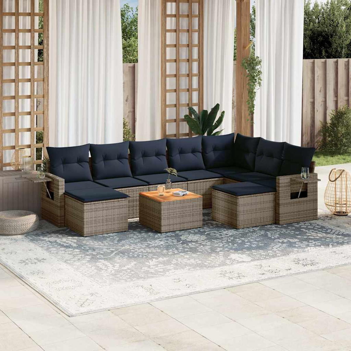 Garten-Sitzgruppe mit blauen Kissen auf einem gemusterten Teppich. Enthält einen Couchtisch und Vorhänge.