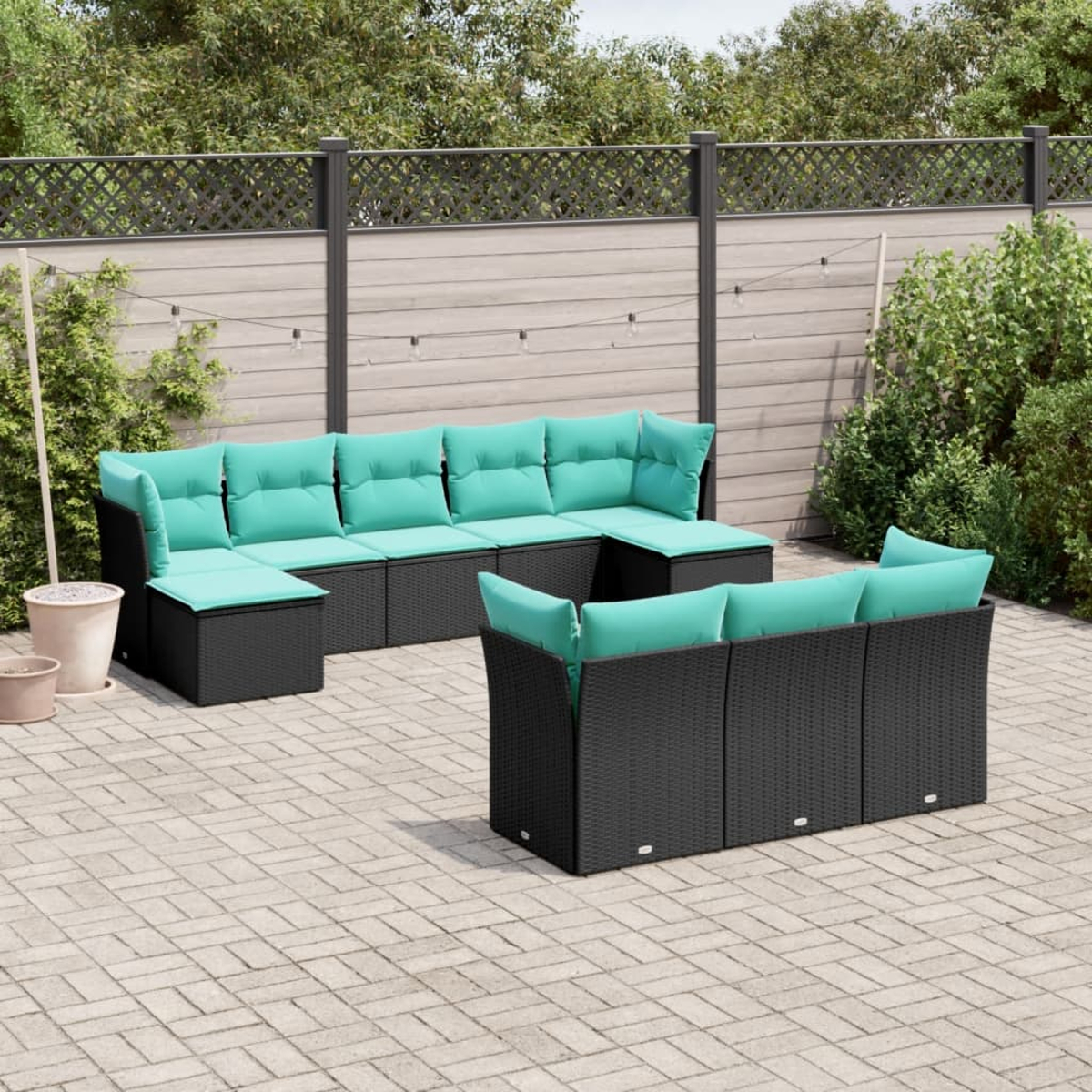 Szene im Freien mit schwarzen Korbmöbeln und türkisfarbenen Kissen. Auf einer Backstein-Terrasse befinden sich ein großes Ecksofa und eine kleinere Couch.
