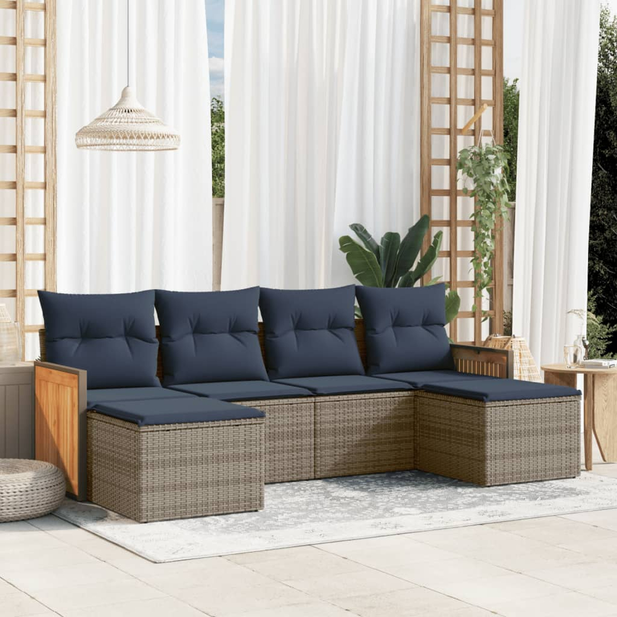 Outdoor-Sitzgarnitur mit blauen Kissen. Weiße Vorhänge im Hintergrund, mit Holzgitter und Hängepflanze. Neutrales Farbschema.
