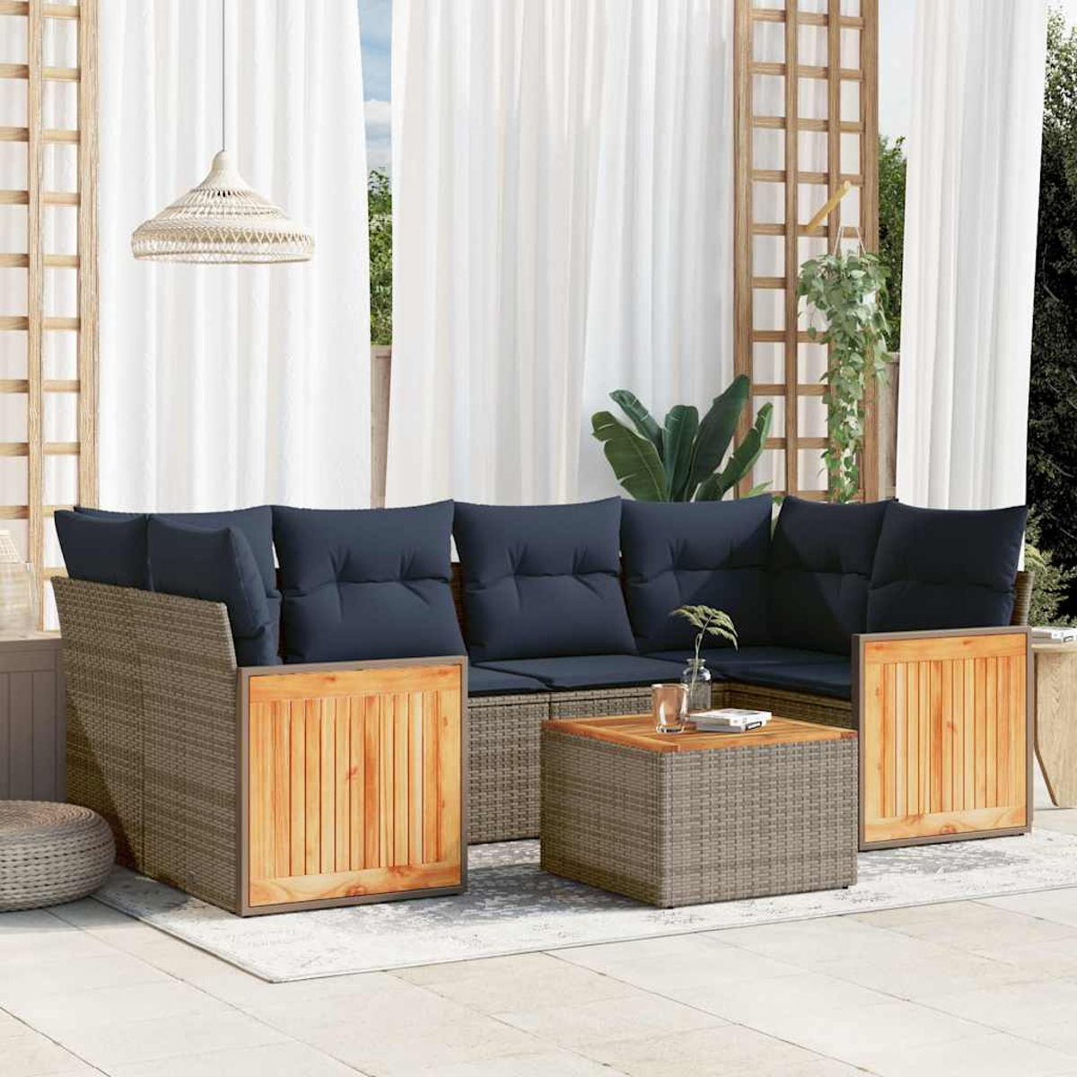 Gartensektionssofa mit marineblauen Kissen, Holzakzenten und einem quadratischen Couchtisch. Weiße Vorhänge und Pflanzen im Hintergrund.
