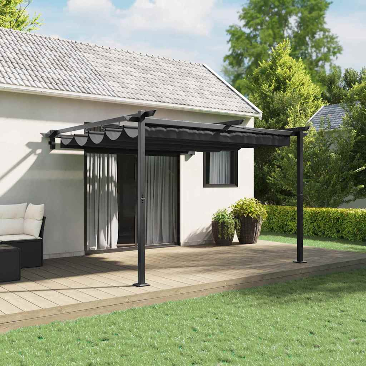 Una pergola nera su un terrazzo in legno, con una casa bianca e erba verde sullo sfondo.