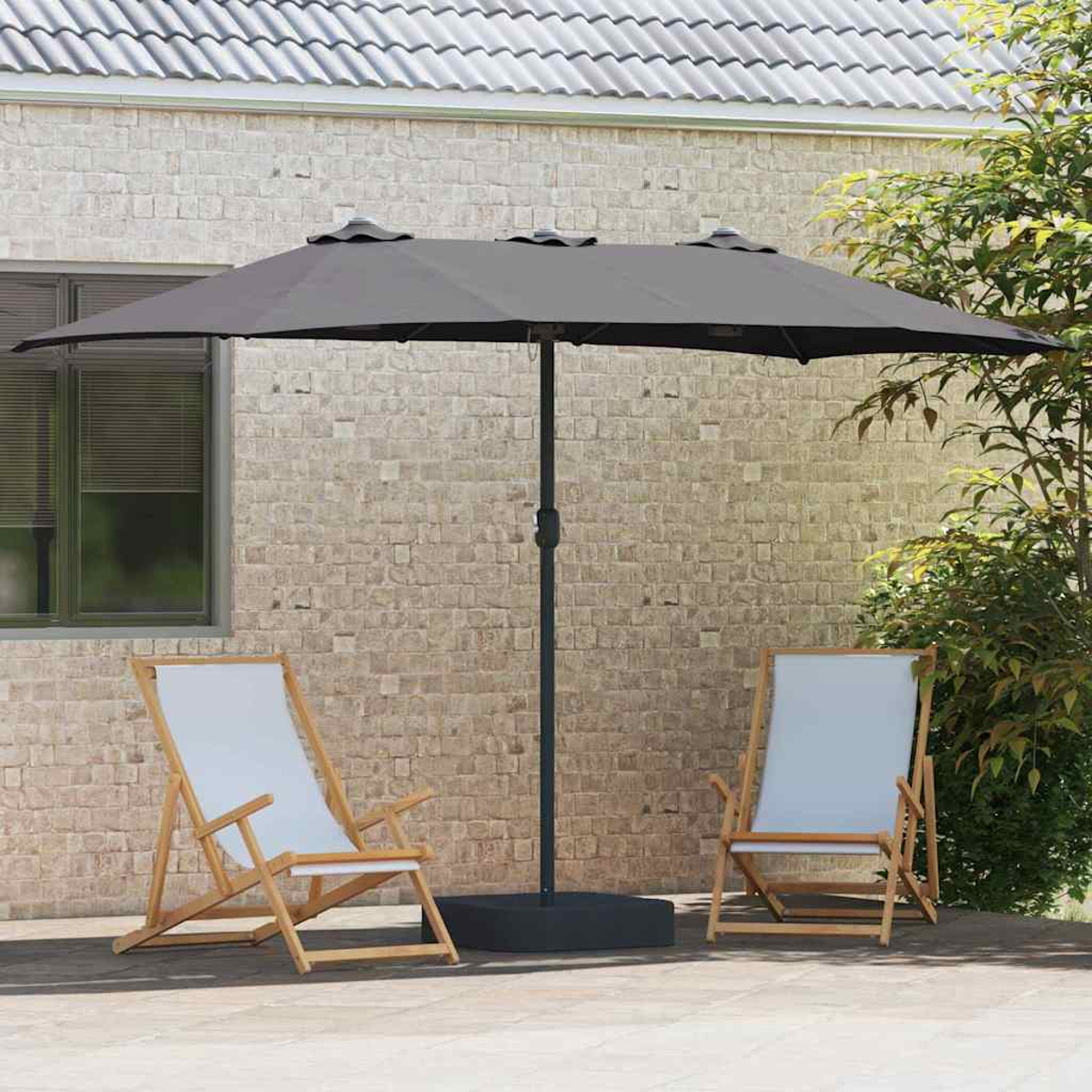 Due sedie con seduta bianca e un ombrellone grigio su un patio. Sullo sfondo un muro di mattoni.