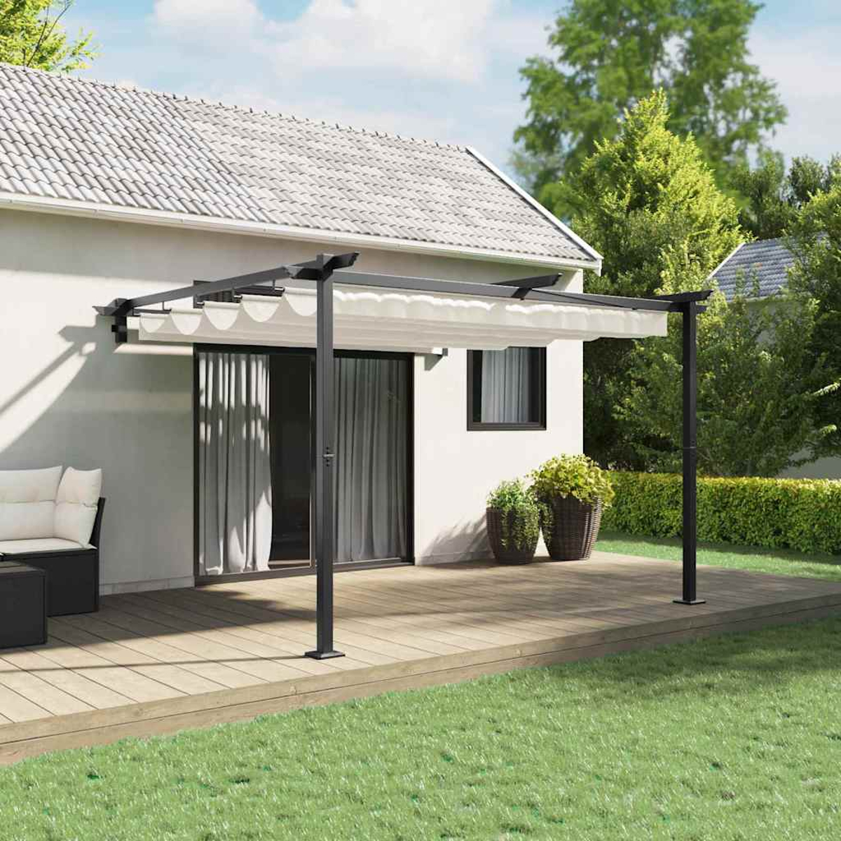 Ein weißes Haus mit Pergola, Holzterrasse, grünem Gras und Topfpflanzen. Bäume im Hintergrund, sonniger Tag.