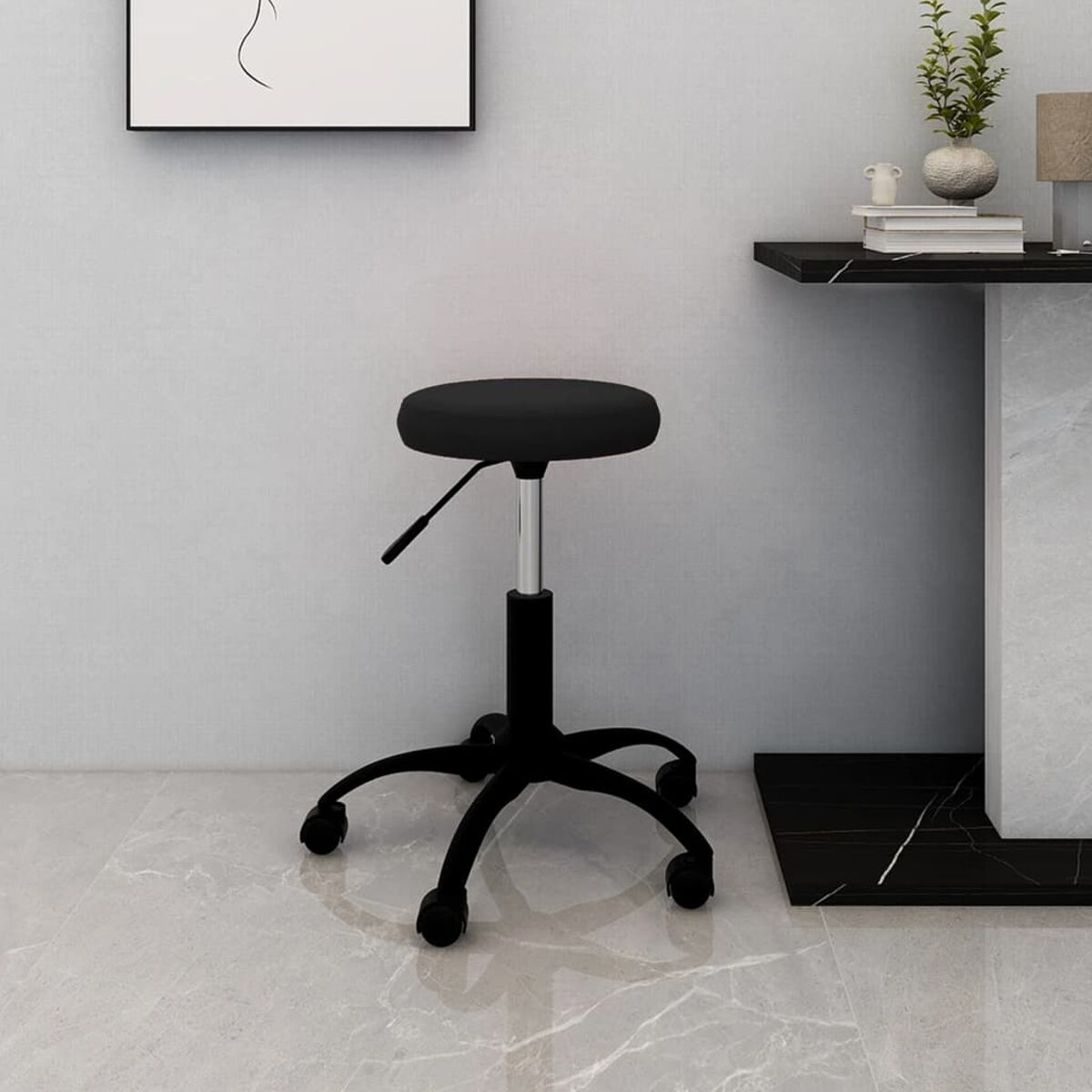 Un taburete negro ajustable está sobre un suelo de mármol. A la derecha hay una mesa negra con plantas y libros.