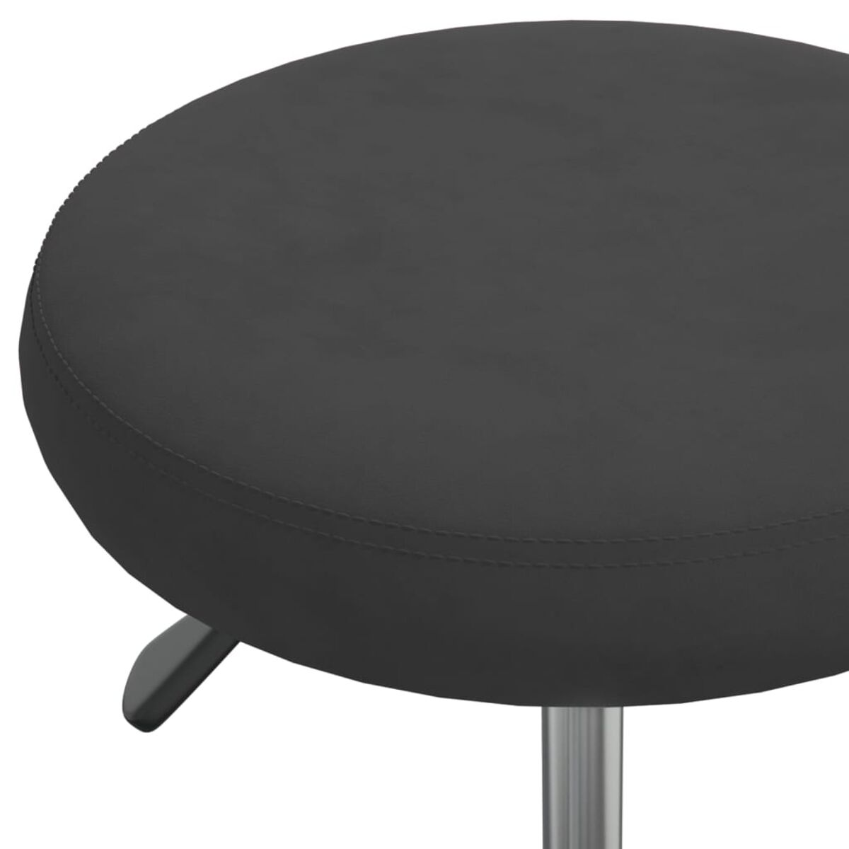 Primer plano de un taburete negro. El taburete tiene un asiento redondo con borde cosido. Tiene una pata de metal y un reposapiés.