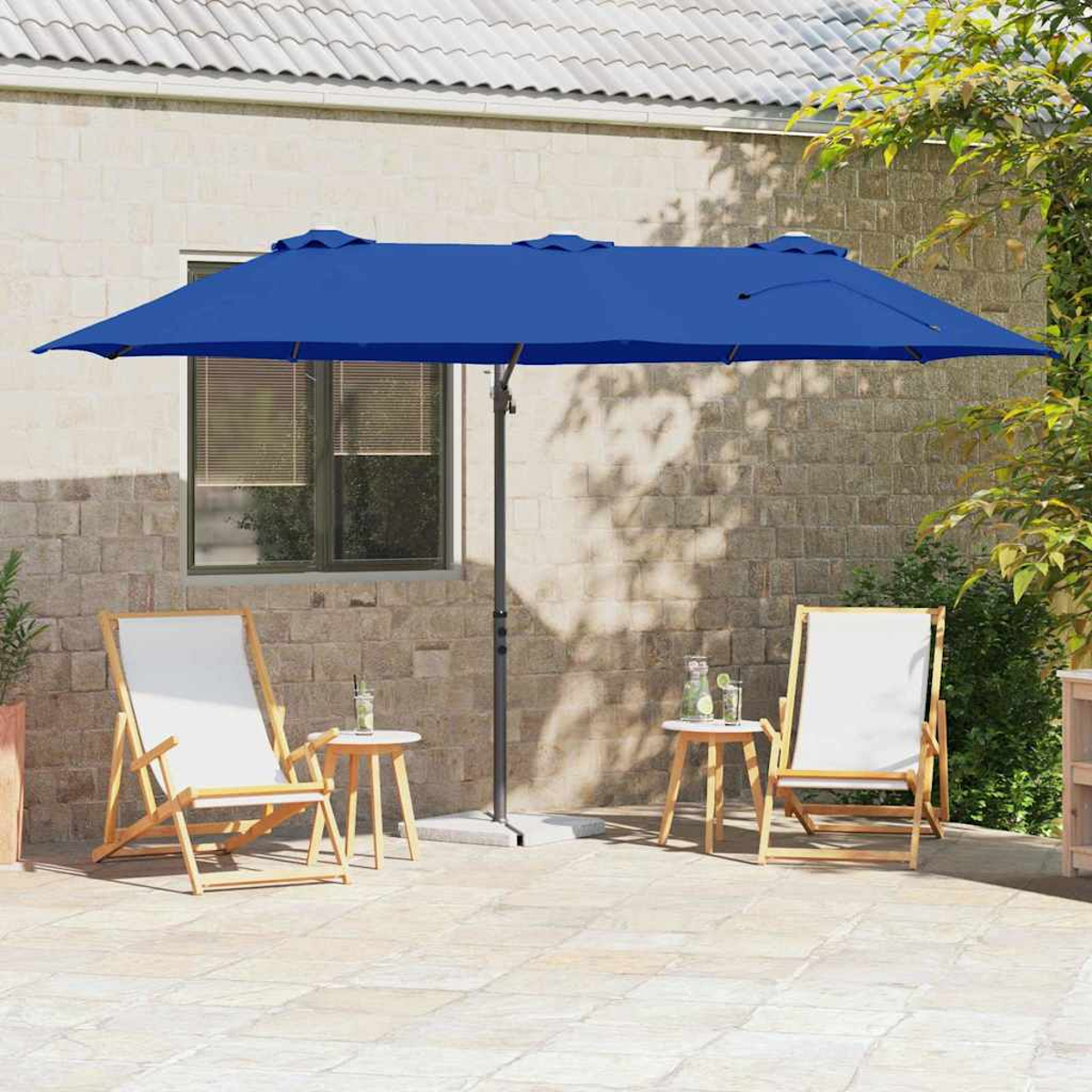 Una scena del patio con un ombrello blu, due sedie, tavolini e uno sfondo di muro di mattoni.