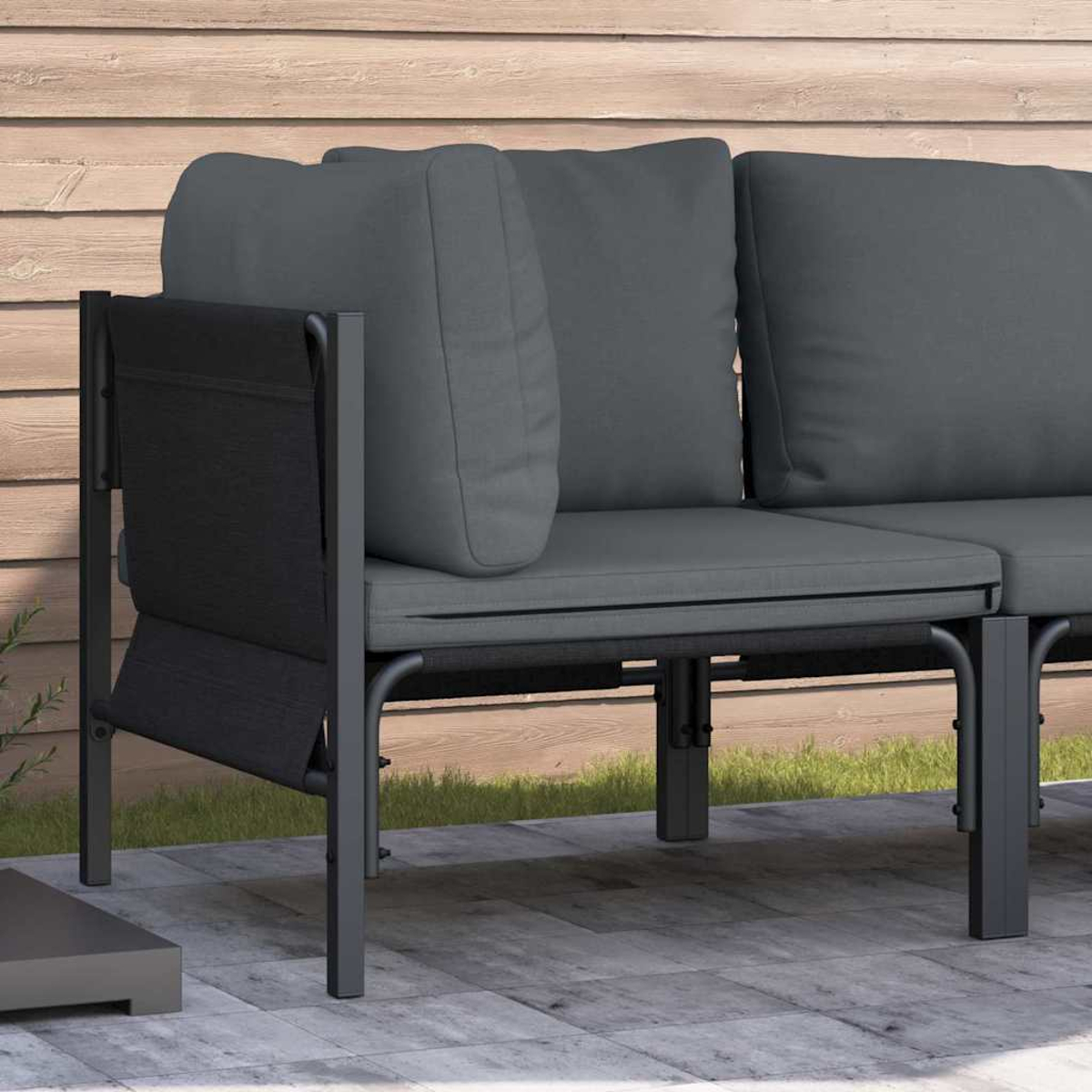 Ein graues Outdoor-Sofa mit Kissen steht auf einer Terrasse. Holzverkleidung bildet den Hintergrund.