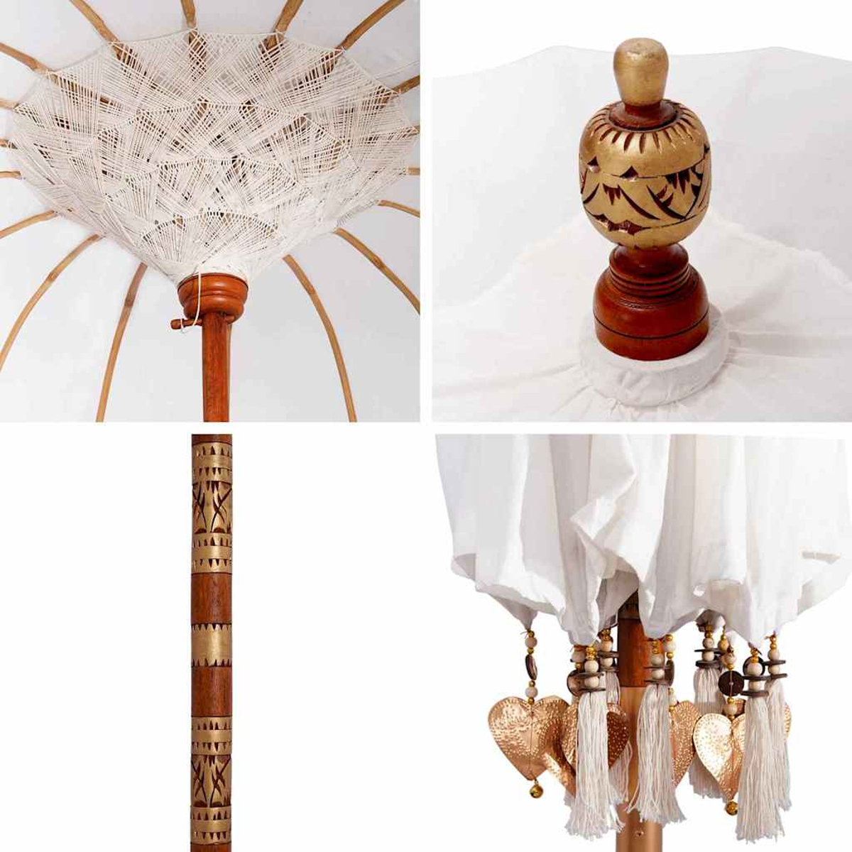 Primo piano di un ombrello decorativo. Presenta tessuto bianco, struttura in legno, ciondoli a forma di cuore dorati e nappe.