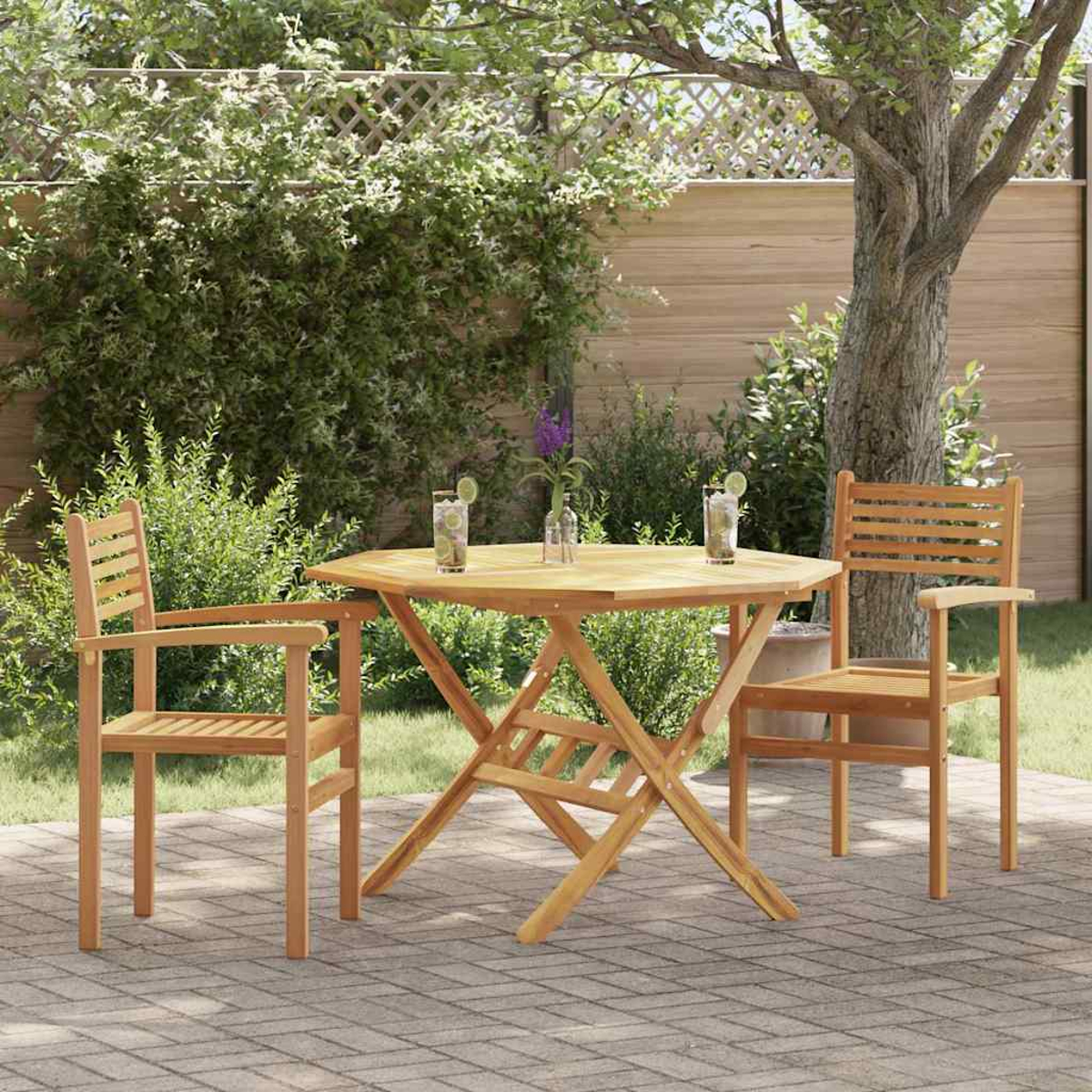Ein Holztisch und Stühle auf einer Terrasse. Getränke stehen auf dem Tisch. Grünes Laub und ein Baum umgeben das Set.