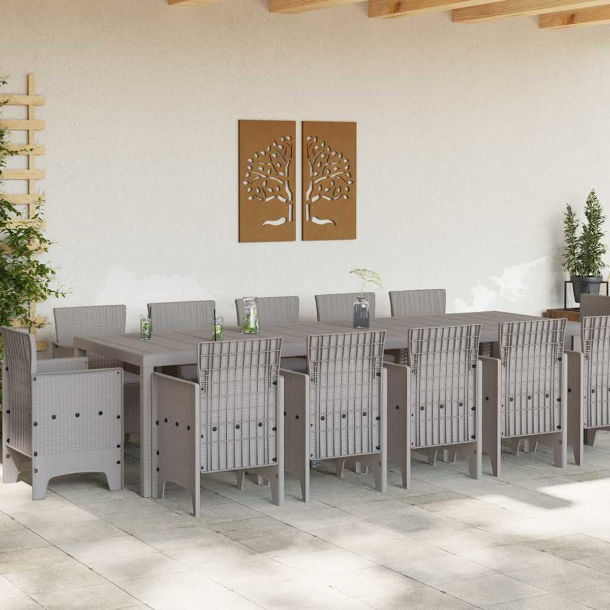Essgruppe im Freien: grauer Tisch und Stühle. Dekorative Baumplatten an der Wand. Pflanzen im Hintergrund.