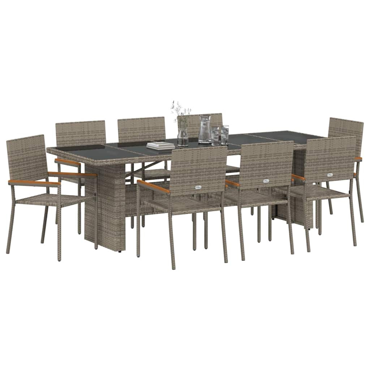 Un juego de comedor de ratán con una mesa rectangular y ocho sillas. La mesa tiene una parte superior oscura y hay un vaso de agua.