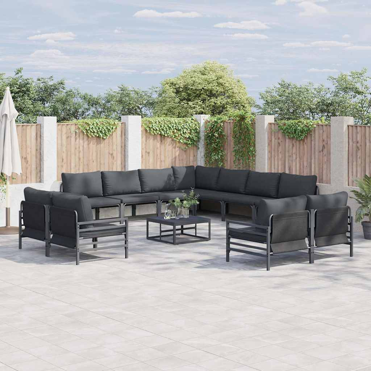 Garten-Terrassenset mit dunkelgrauen Kissen und Metallrahmen. Enthält ein Ecksofa, Sessel und einen Couchtisch auf einer Terrasse.