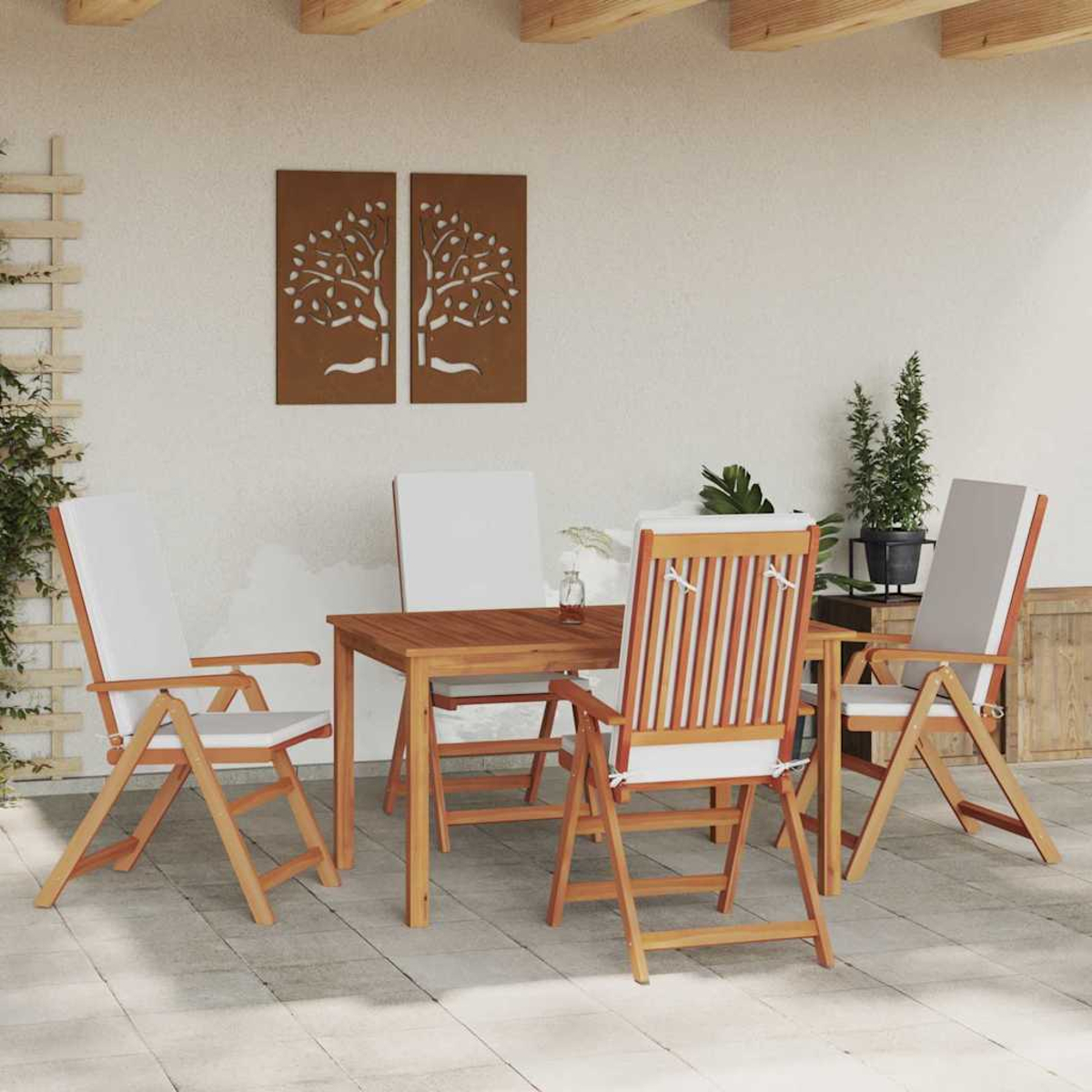 Outdoor-Set mit Holzstühlen, Tisch und Kissen. Dekorative Wandkunst und Pflanzen im Hintergrund. Terrasse.