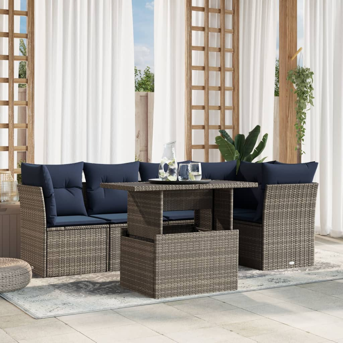 Garten-Sitzgruppe mit blauen Kissen und einem Tisch auf der Terrasse. Weiße Vorhänge und Pflanzen im Hintergrund.