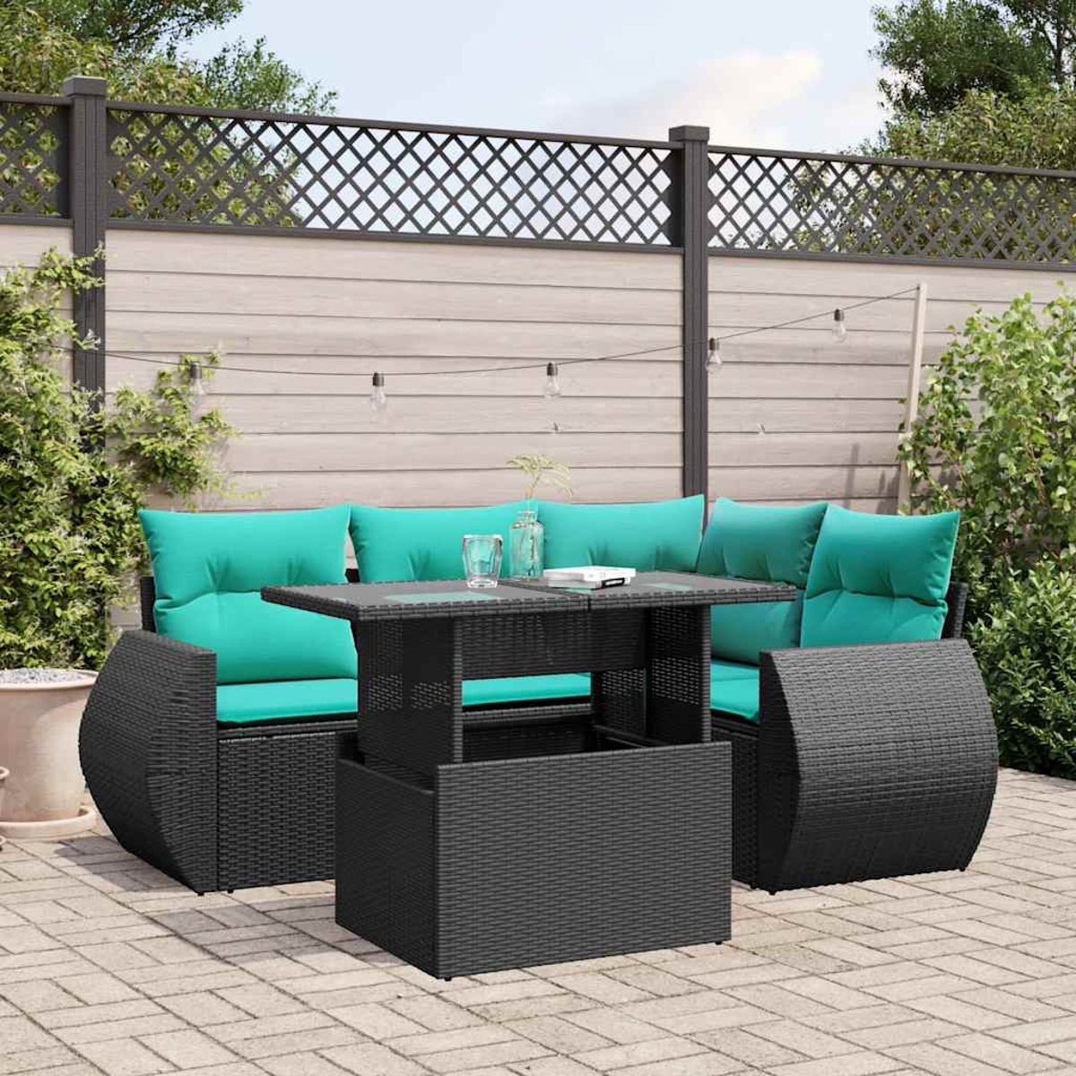 Gartenmöbel-Set mit türkisfarbenen Kissen und einem schwarzen Tisch. Eine Ziegelterrasse mit Holzzaun im Hintergrund.