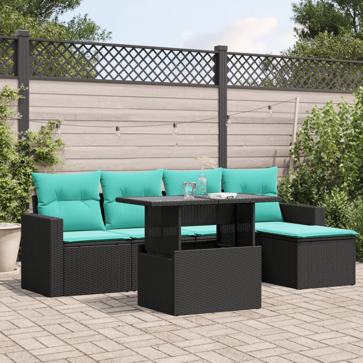 Terrassenset mit schwarzem Korbmöbeln und türkisfarbenen Kissen. Enthält ein Sofa, einen Tisch und einen Stuhl, vor einem Zaun.