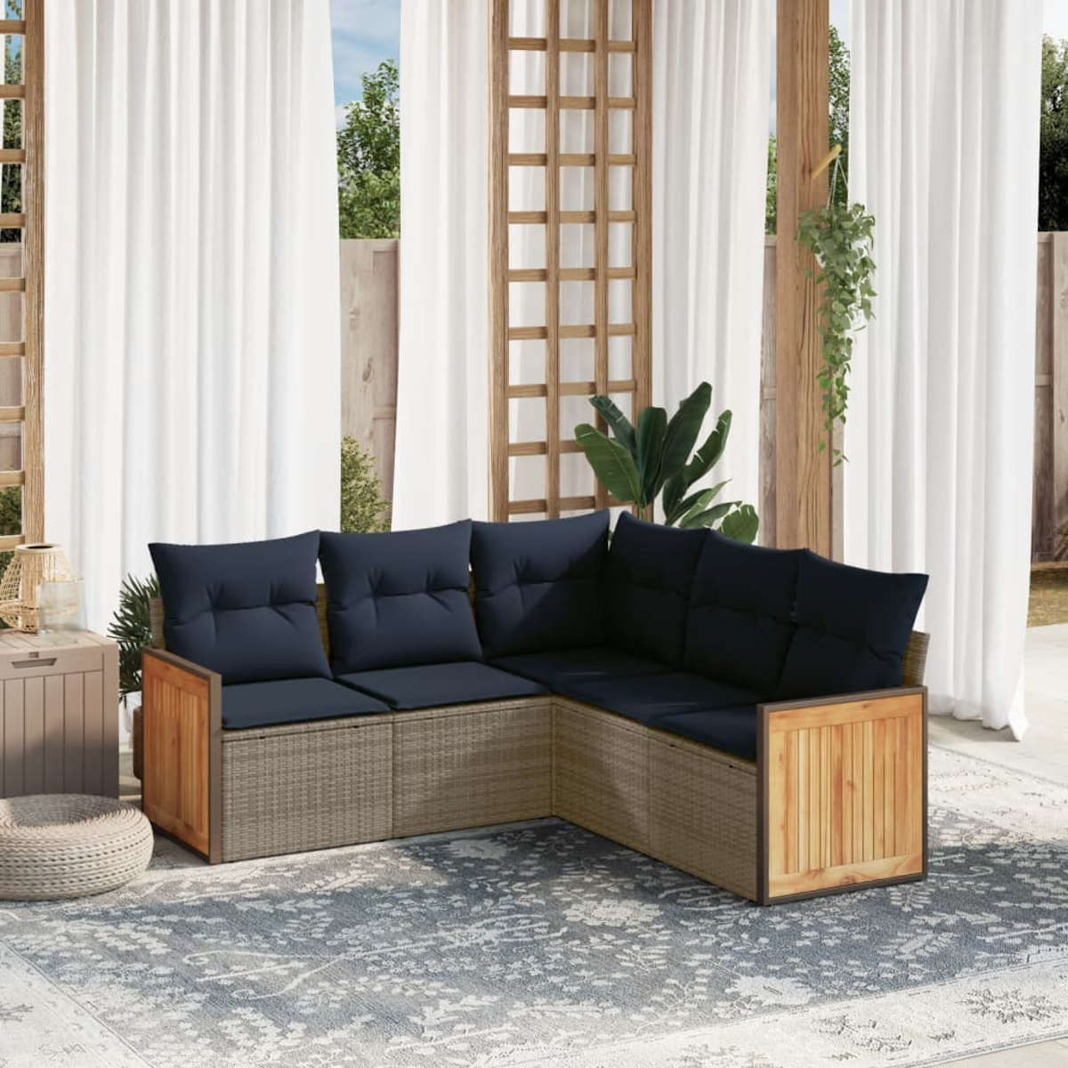 Ein Ecksofa im Freien mit marineblauen Kissen steht auf einem gemusterten Teppich. Weiße Vorhänge und Holzbalken umrahmen die Szene.