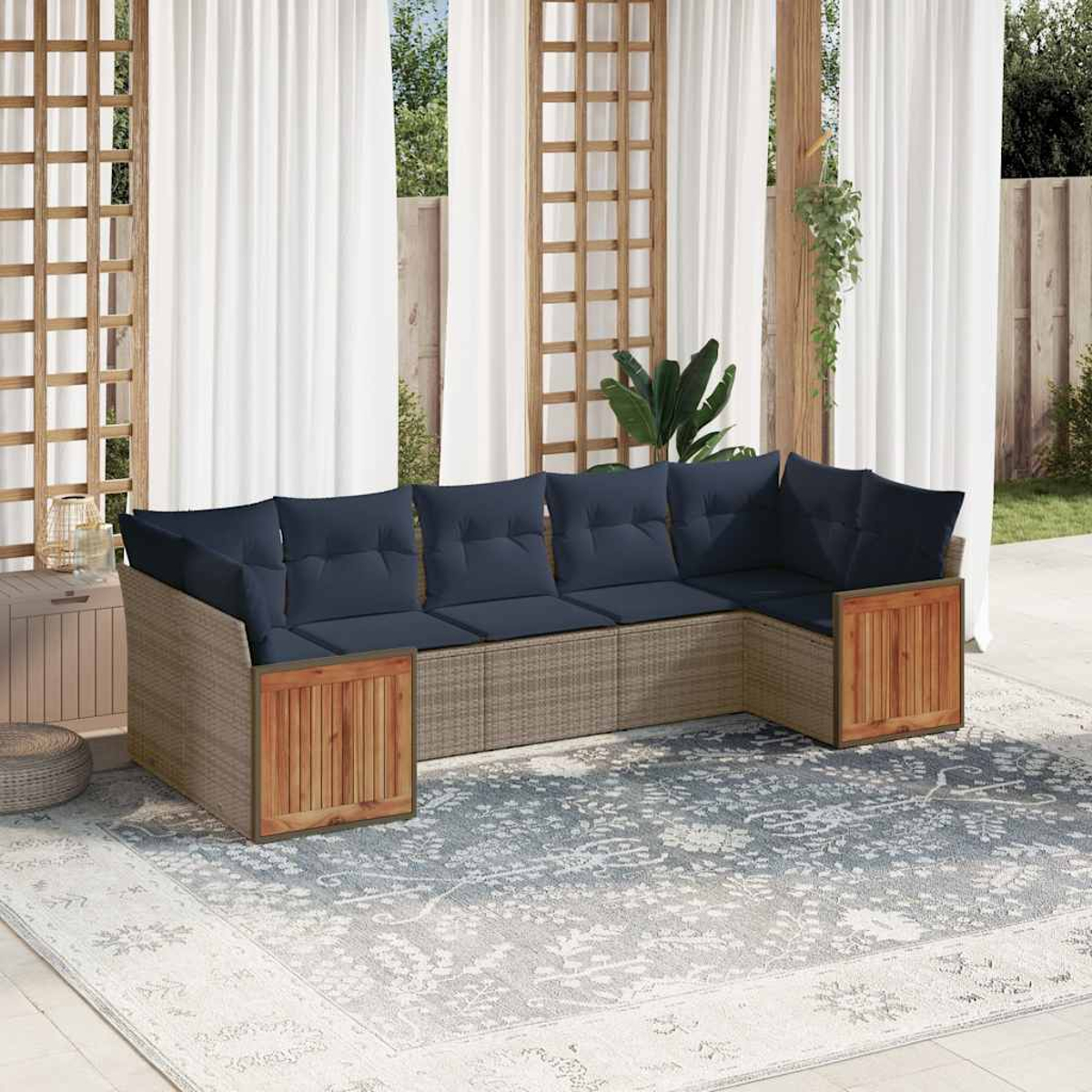 Ein Ecksofa im Freien mit marineblauen Kissen auf einem gemusterten Teppich, mit weißen Vorhängen und einer Holzstruktur im Hintergrund.