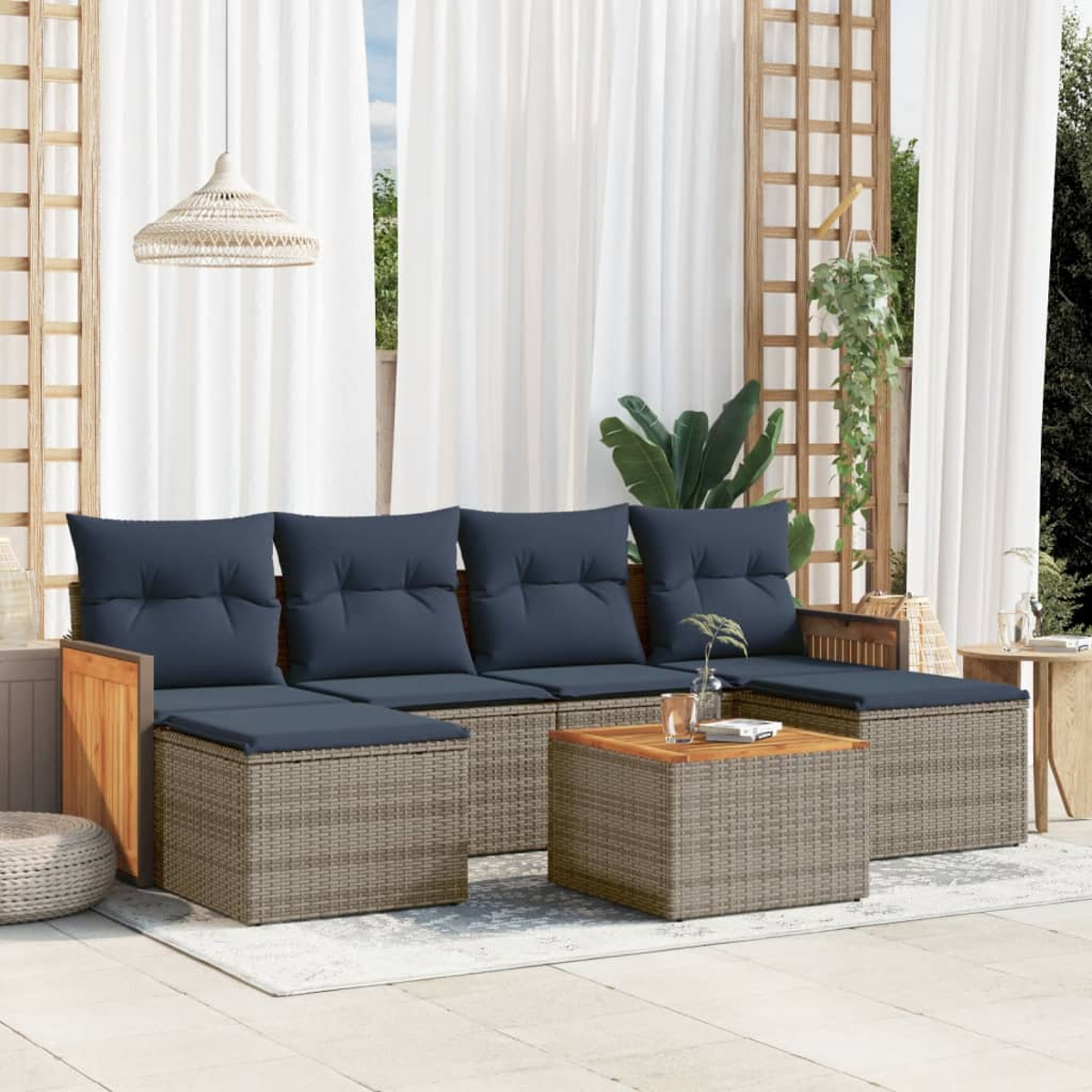 Outdoor-Ecksofa mit blauen Kissen, Korbrahmen, Holzakzenten, Couchtisch und weißen Vorhängen im Hintergrund.