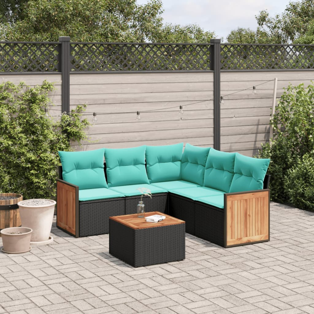 Outdoor-Ecksofa mit türkisfarbenen Kissen und einem Holztisch. Im Hintergrund sind ein Holzzaun und Pflanzen zu sehen.