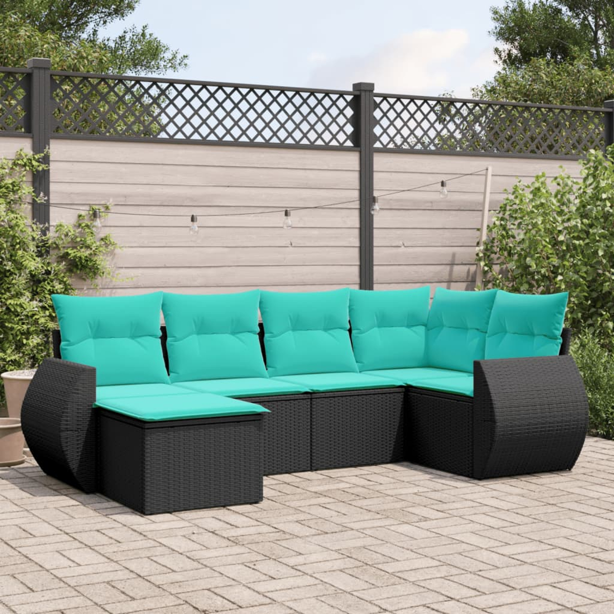 Outdoor-Ecksofa mit schwarzem Korbmöbelrahmen und türkisfarbenen Kissen auf einer Ziegelterrasse. Zaun und Laub im Hintergrund.