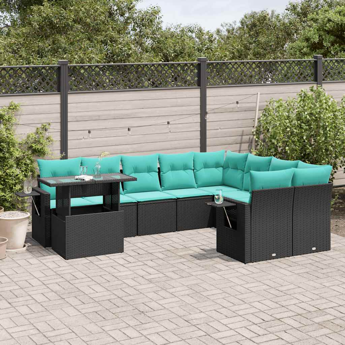 Outdoor-Ecksofa mit türkisfarbenen Kissen und einem Glastisch. Auf einer Terrasse mit Zaun und Grün im Hintergrund.