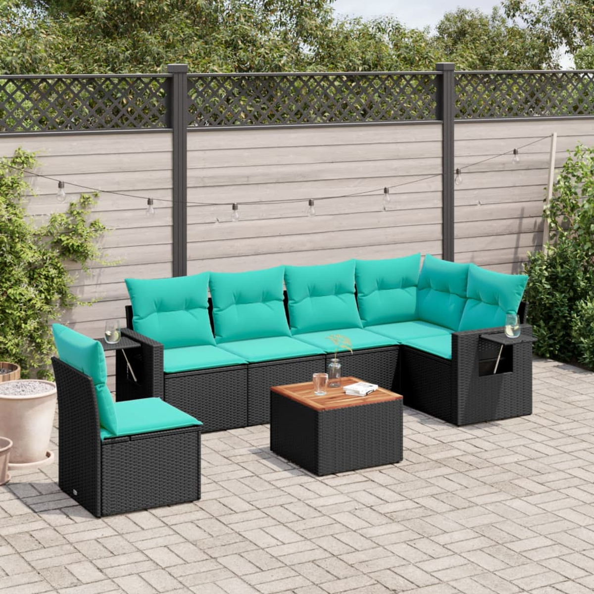Schwarzes Rattan-Gartenmöbel-Set mit türkisfarbenen Kissen auf einer Terrasse. Enthält Sofa, Stuhl und einen Couchtisch.