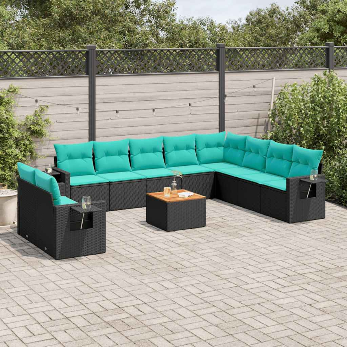 Garten-Sitzgruppe mit schwarzen Korbflechtrahmen und türkisfarbenen Kissen auf einer gepflasterten Terrasse. Enthält einen kleinen Couchtisch.