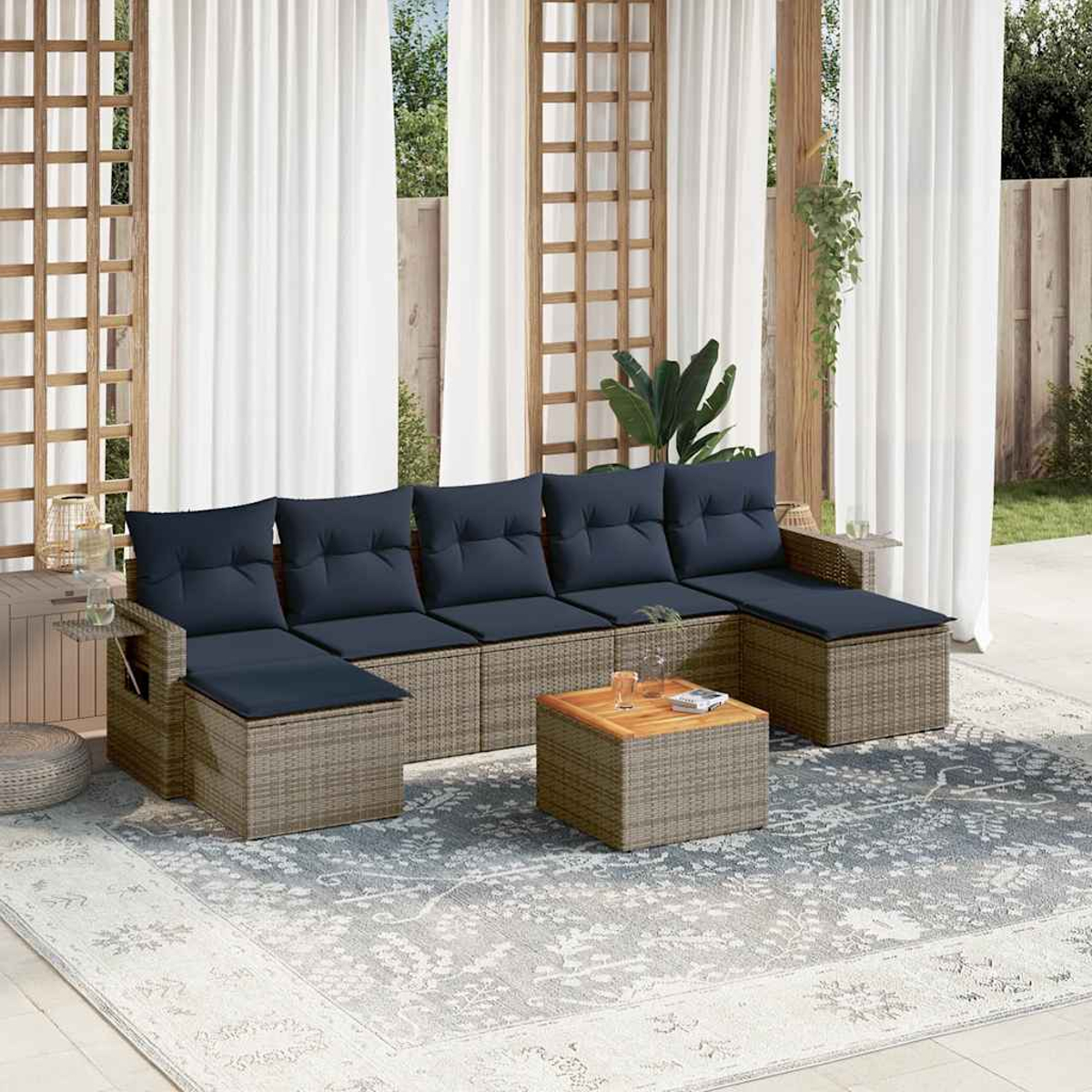 Gartensektionssofa mit marineblauen Kissen, einem Couchtisch aus Holz und einem gemusterten Teppich. Weiße Vorhänge und ein Gitterhintergrund.
