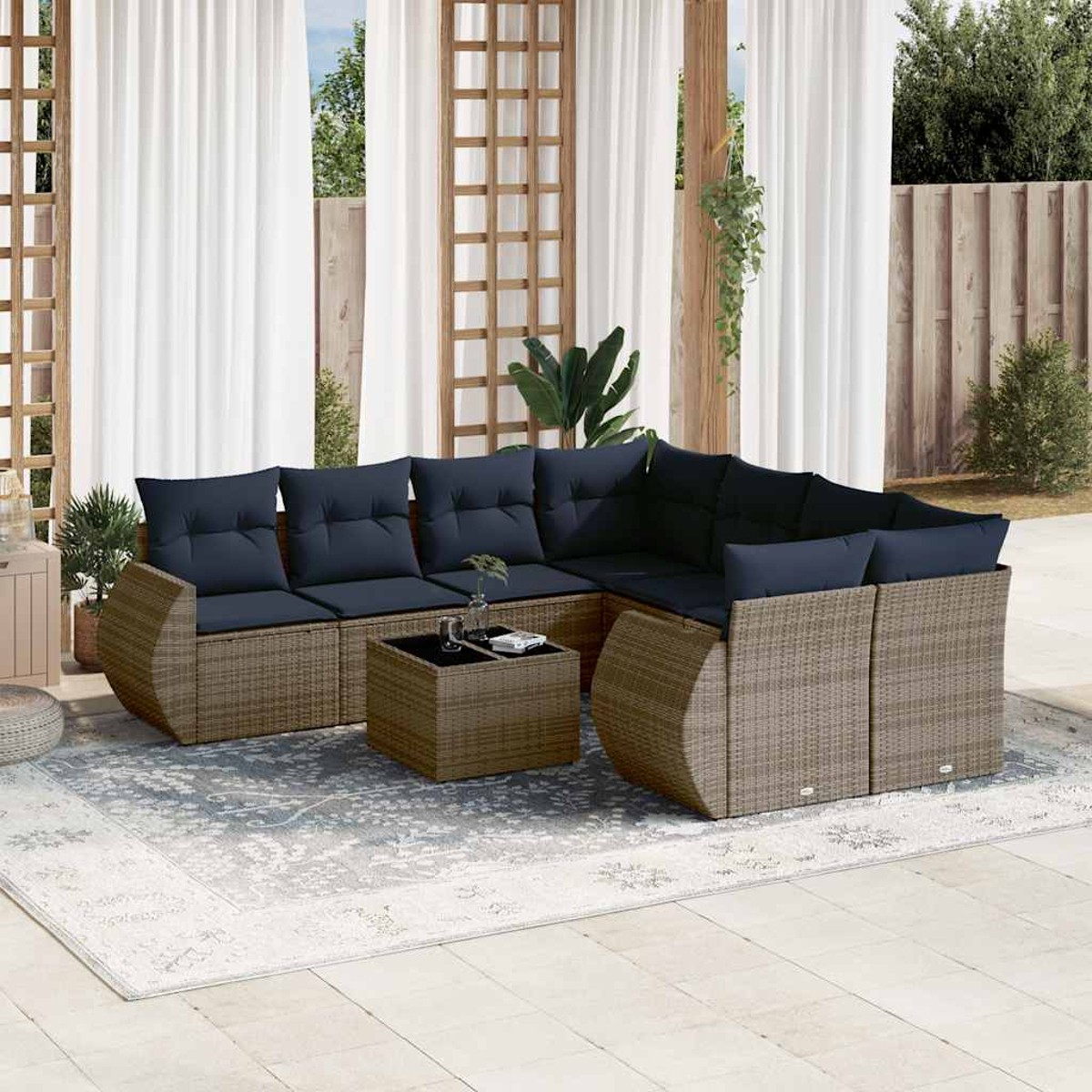 Ein Außenbereich mit einem Ecksofa aus Korbgeflecht mit marineblauen Kissen, einem Couchtisch und einem Teppich.