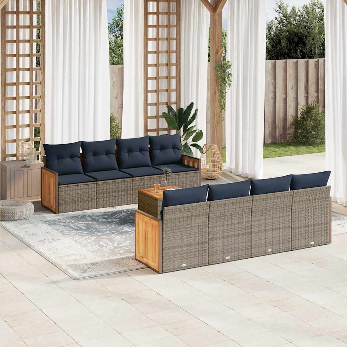 Zona de estar al aire libre con dos sofás, cojines azules, marcos de madera y una mesita. Cortinas blancas y vegetación al fondo.