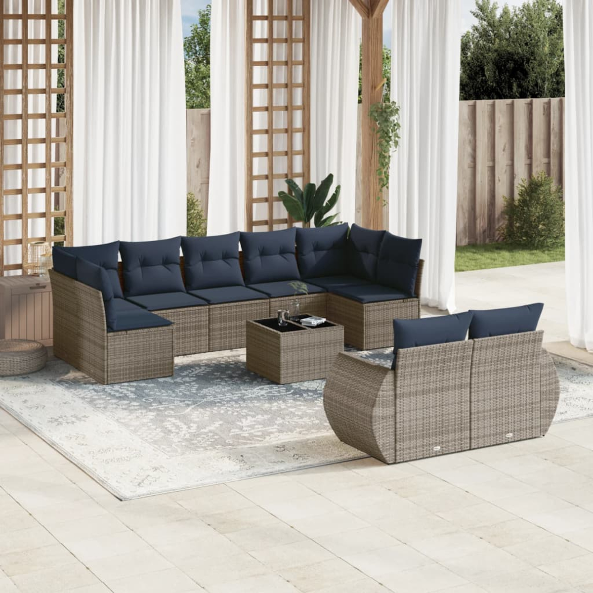 Outdoor-Korbmöbel-Set mit blauen Kissen. Beinhaltet ein Ecksofa, ein Zweisitzer-Sofa und einen Couchtisch auf einer Terrasse mit Vorhängen.