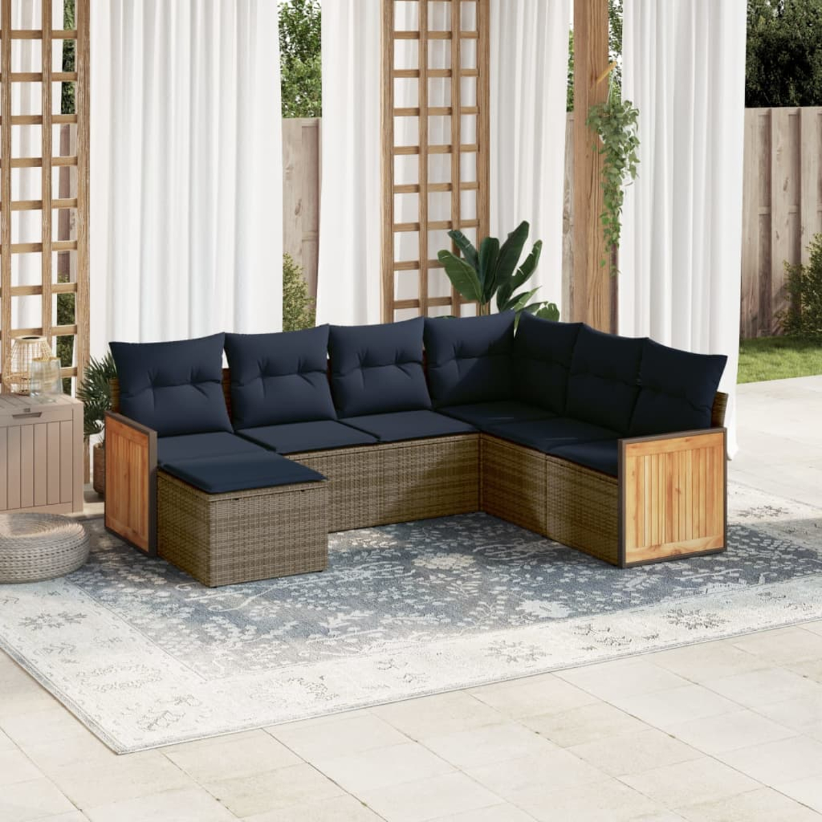 Outdoor-Ecksofa mit marineblauen Kissen auf einem gemusterten Teppich. Vorhänge und Holzrahmen im Hintergrund.