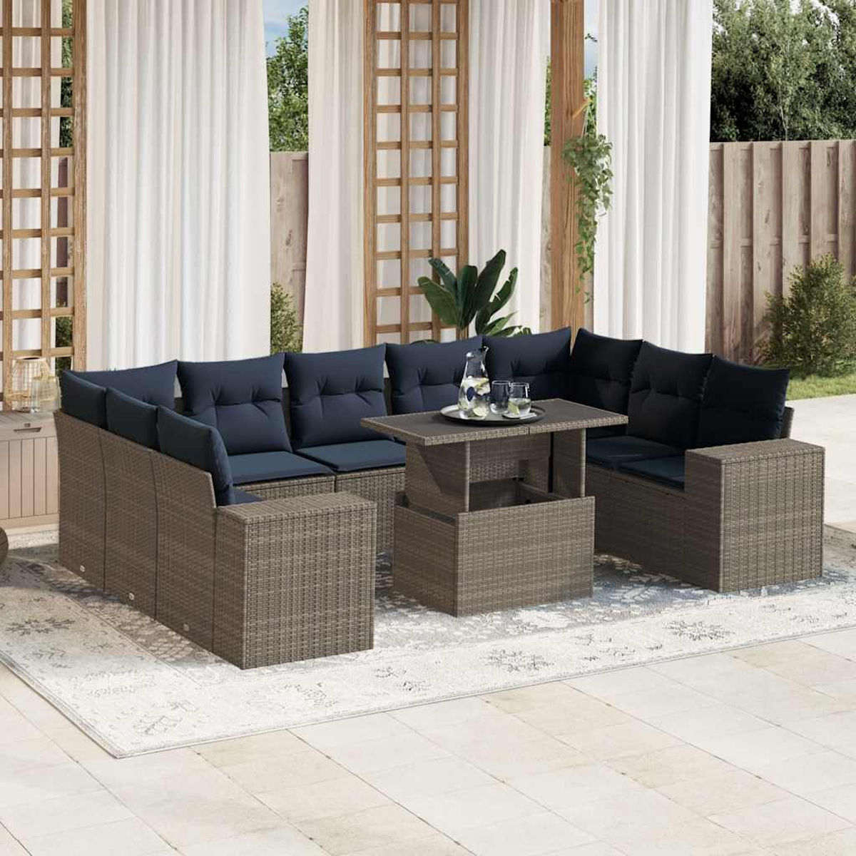 Outdoor-Set mit Korbmöbeln, blauen Kissen, einem Tisch mit Getränken und weißen Vorhängen auf einem Teppich.