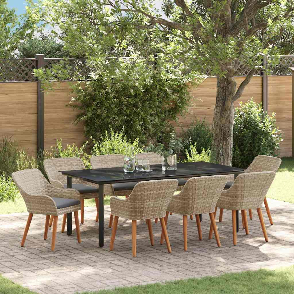Ein schwarzer Tisch mit acht Korbstühlen steht auf einer Terrasse. Die Szene ist im Freien mit Holzzaun und grünem Laub im Hintergrund.
