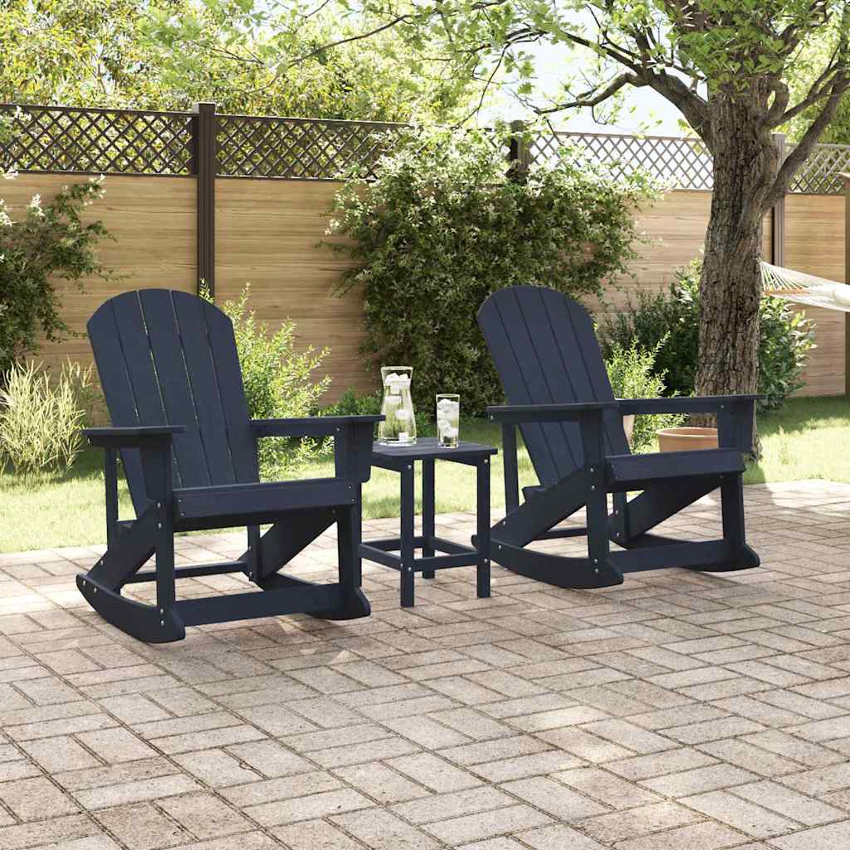 Zwei marineblaue Adirondack-Stühle und ein kleiner Tisch auf einer Ziegelterrasse. Ein Zaun und Bäume sind im Hintergrund.