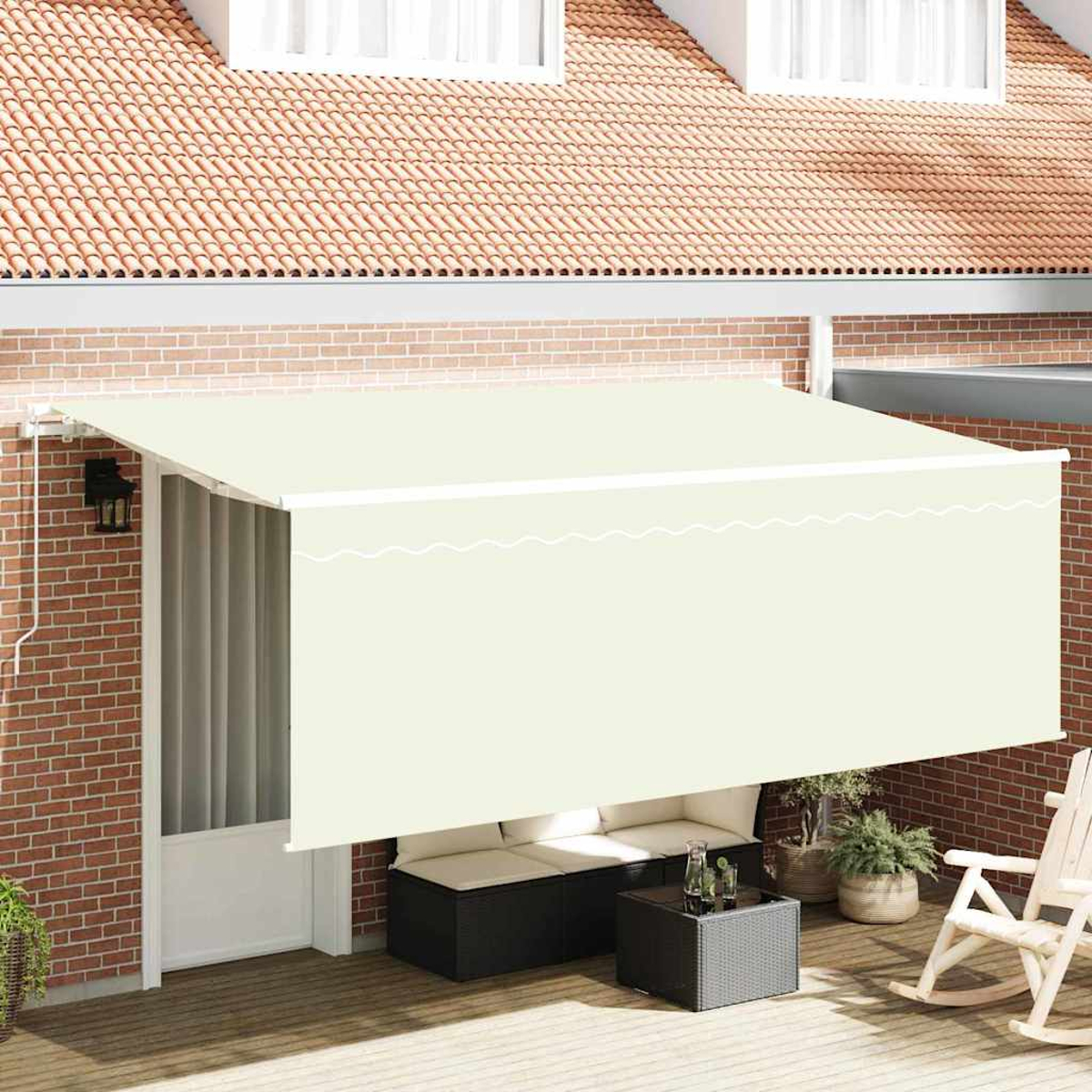 Eine beige Markise erstreckt sich über eine Terrasse mit einer weißen Tür. Es gibt eine Ziegelmauer, ein Sofa, einen Tisch, Topfpflanzen und einen Schaukelstuhl.