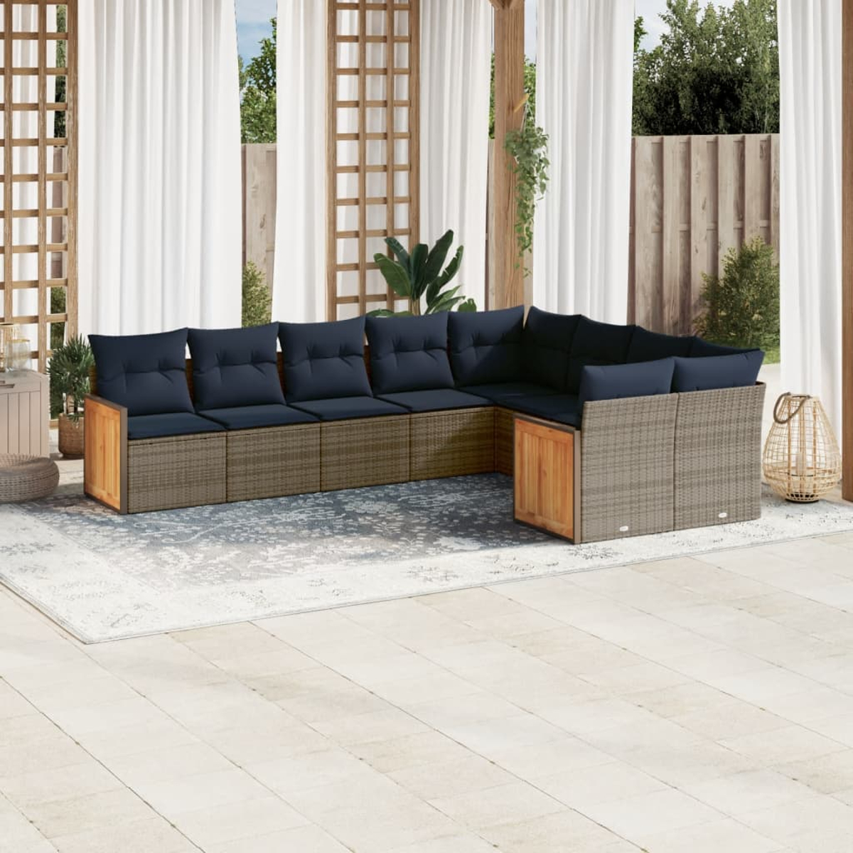 Ein Ecksofa im Freien mit marineblauen Kissen steht auf einem Teppich. Weiße Vorhänge und ein Holzgitter sind im Hintergrund.