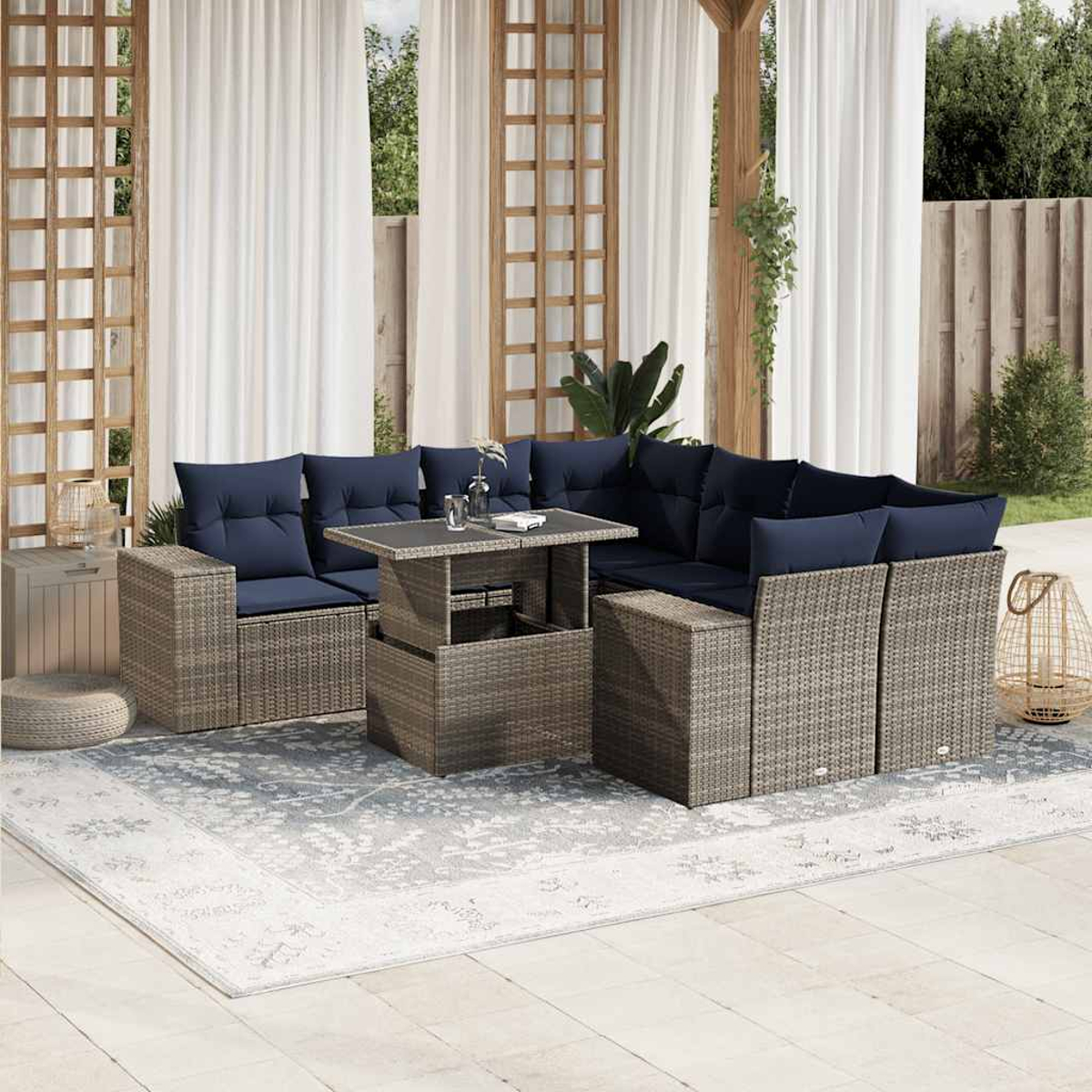 Outdoor-Ecksofa mit marineblauen Kissen und einem Tisch mit Hubfunktion auf einem gemusterten Teppich, vor Vorhängen und Holzstruktur.