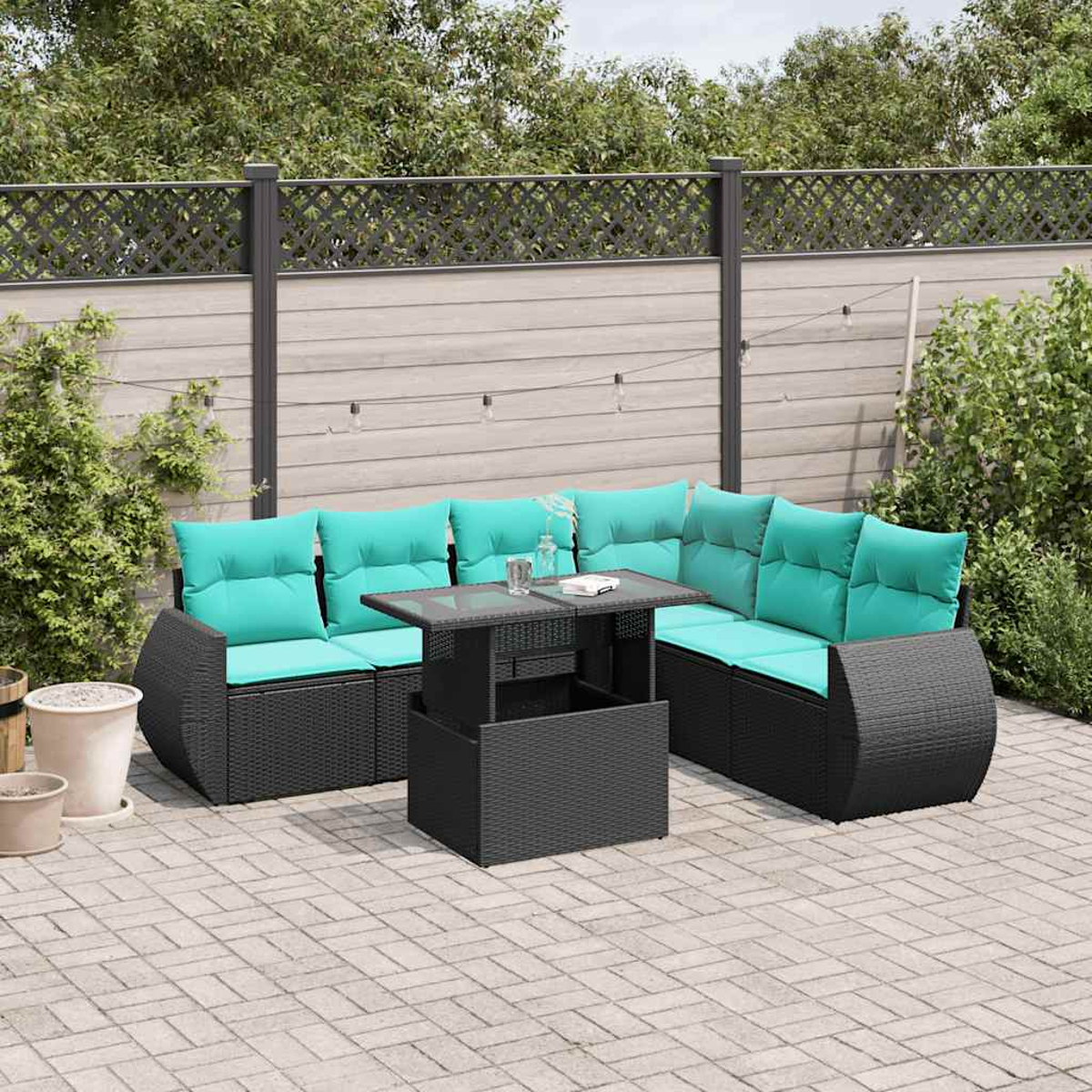 Outdoor-Ecksofa mit türkisfarbenen Kissen und einem Tisch mit Glasplatte. Auf einer Ziegelterrasse, mit Zaun und Grün im Hintergrund.