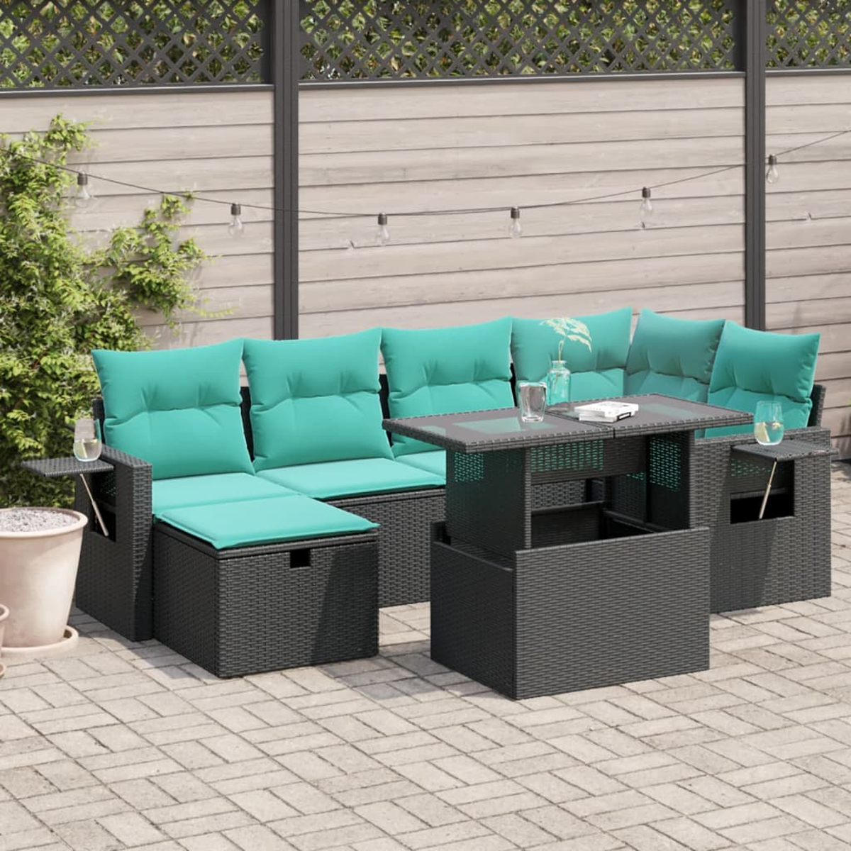 Outdoor-Ecksofa mit türkisfarbenen Kissen, einem Couchtisch mit Hubfunktion und Holzzaun im Hintergrund. Patio-Einstellung.