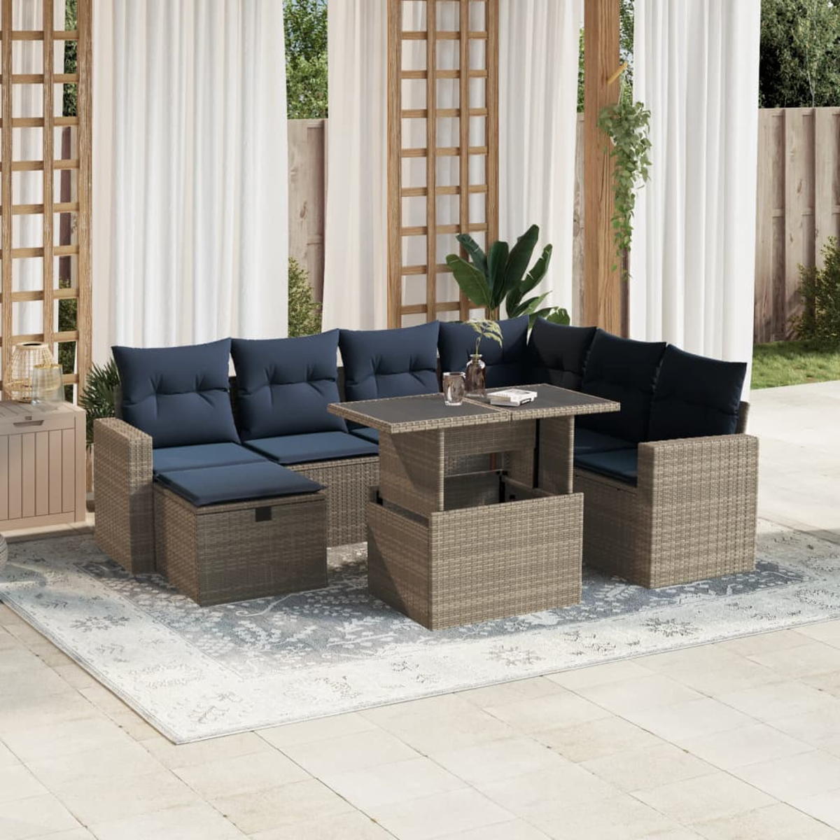 Gartenmöbel-Set aus Korbgeflecht mit marineblauen Kissen. Beinhaltet ein Ecksofa, einen Couchtisch und einen Beistelltisch auf einem Teppich.