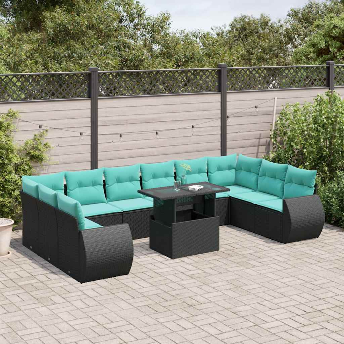 Outdoor-Ecksofa mit türkisfarbenen Kissen und einem schwarzen Tisch auf einer gepflasterten Terrasse. Grünes Laub im Hintergrund.