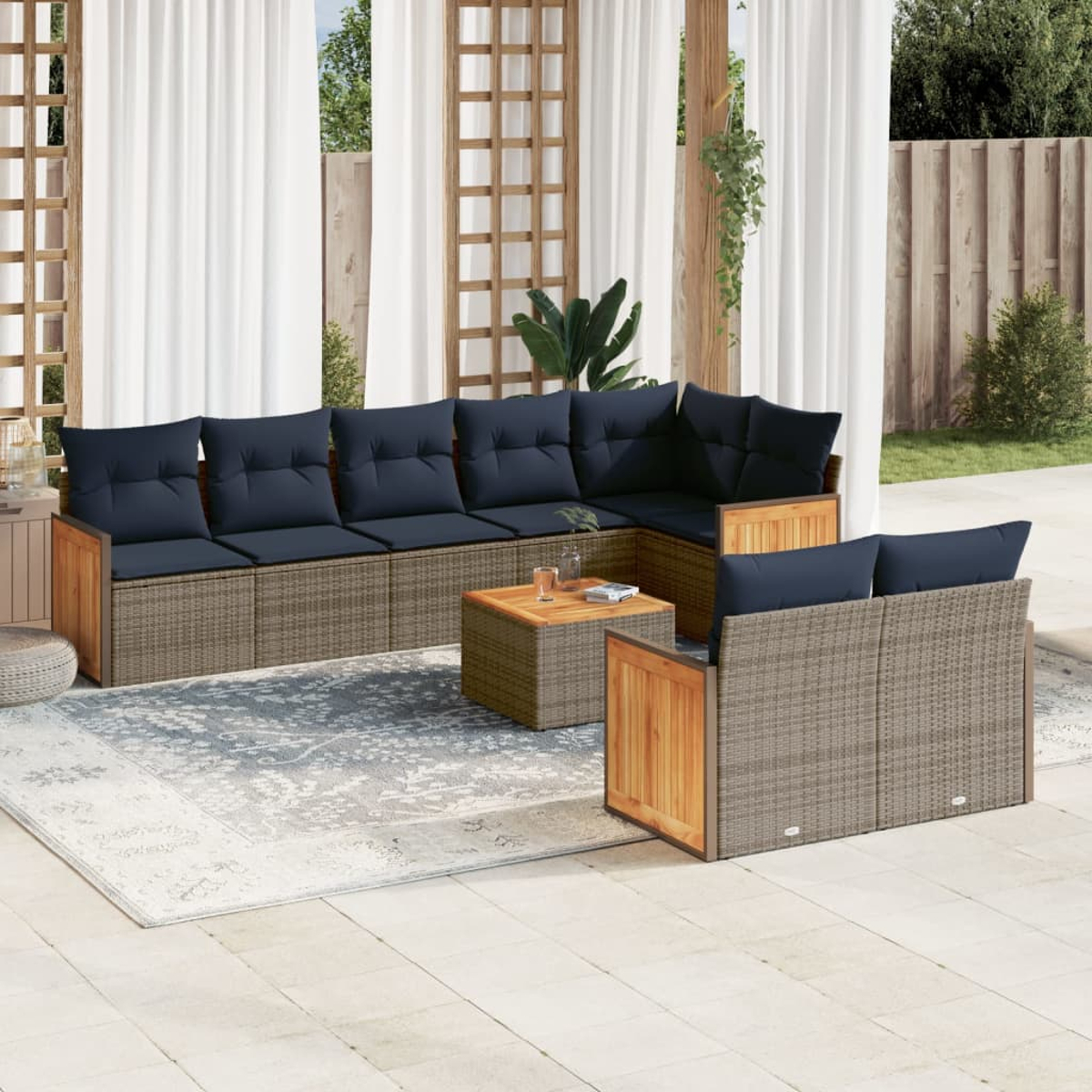 Garten-Sitzgruppe mit dunkelblauen Kissen. Beinhaltet Sofa, Stühle und Couchtisch auf einer Terrasse mit Teppich und Vorhängen.