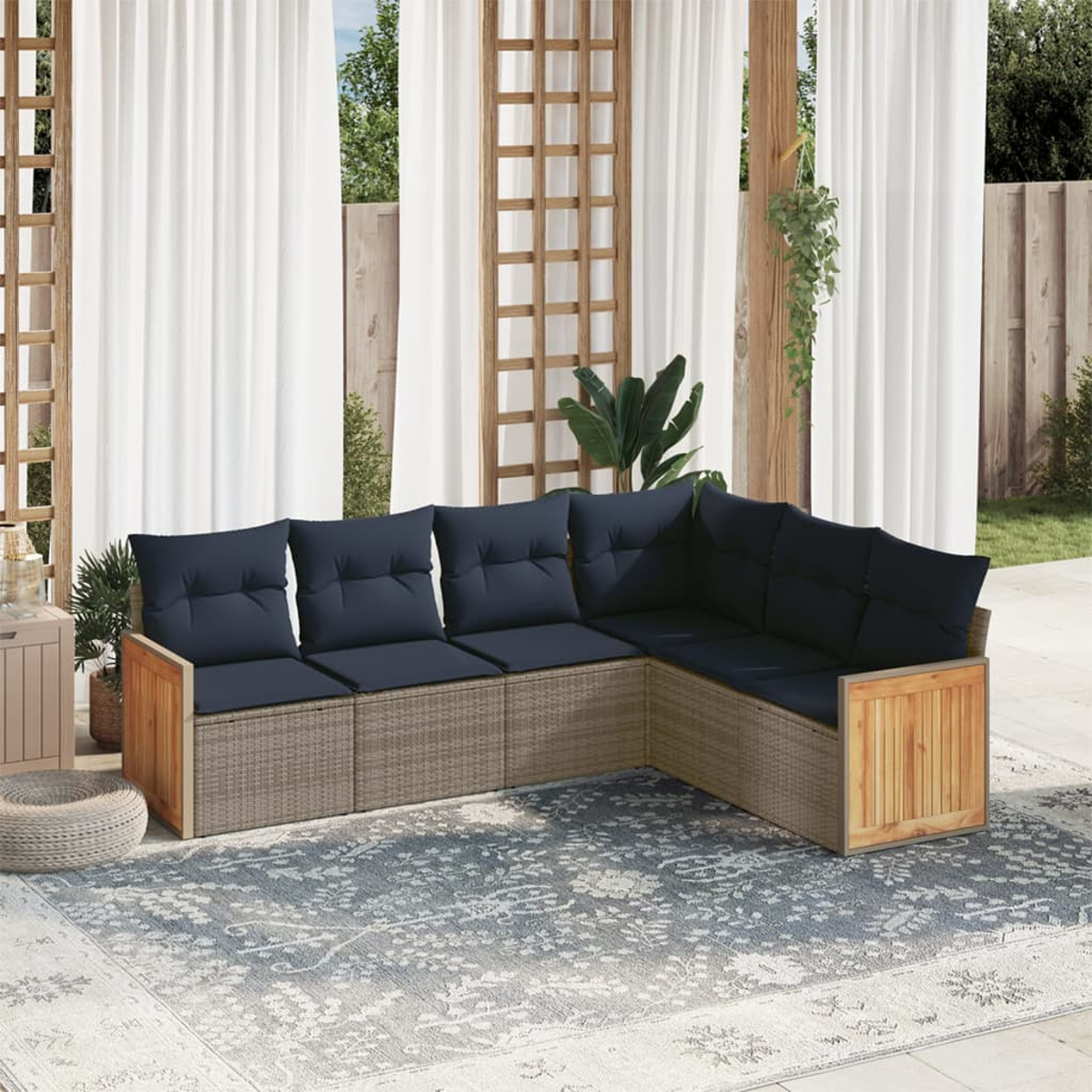 Outdoor-Ecksofa mit marineblauen Kissen. Es steht auf einem gemusterten Teppich. Weiße Vorhänge und Holzgitter im Hintergrund.