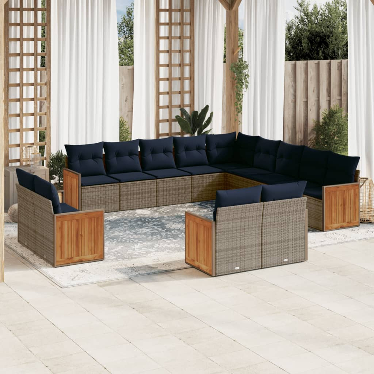 Juego de asientos al aire libre con cojines azules. Cuenta con un gran sofá seccional y dos sillones en un patio. El fondo incluye cortinas y vegetación.