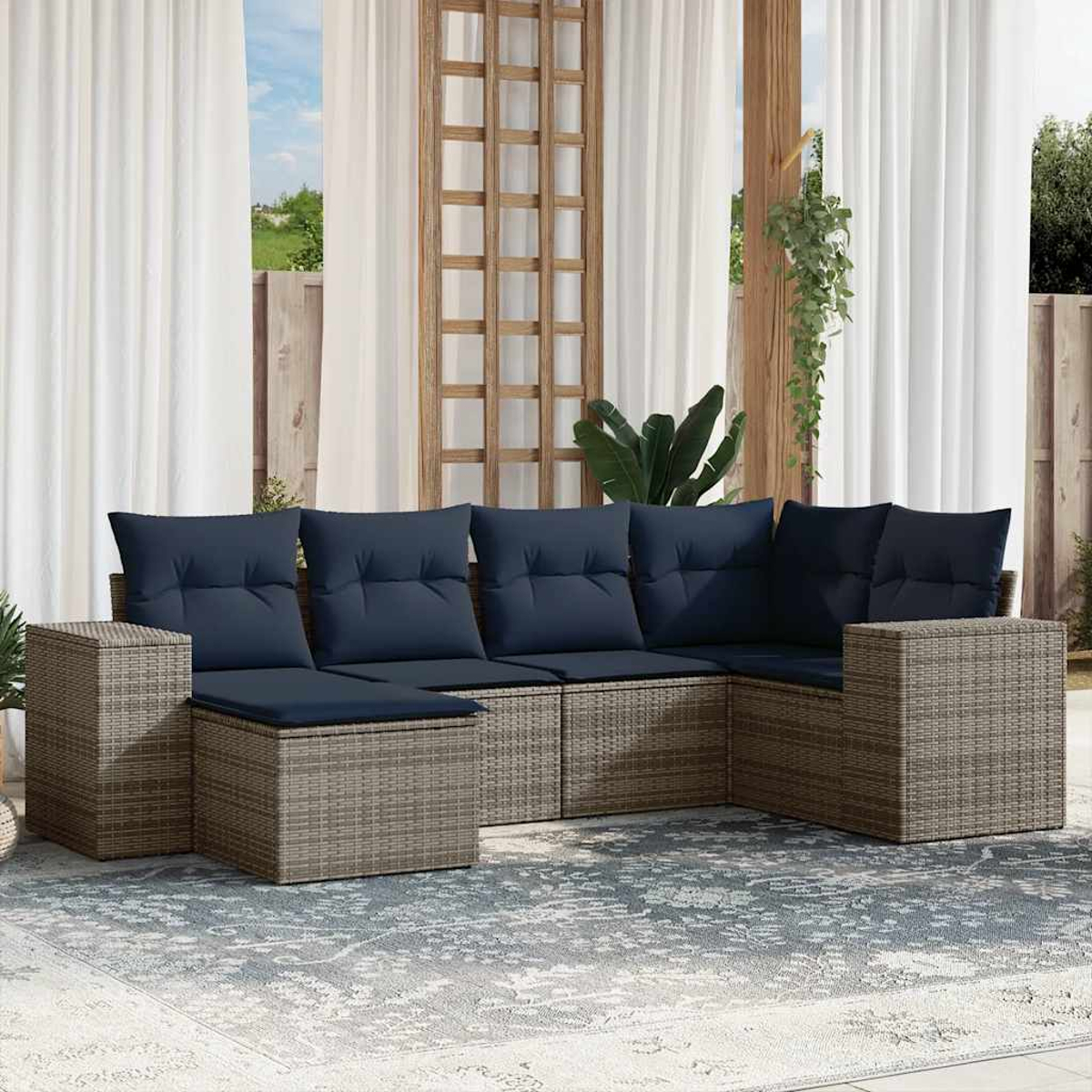 Outdoor-Ecksofa mit marineblauen Kissen steht auf einem Teppich. Weiße Vorhänge und ein Holzgitter im Hintergrund.