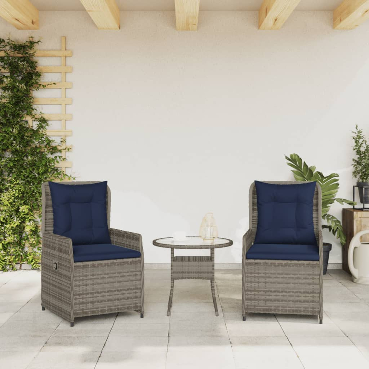 Zwei Korbstühle mit blauen Kissen und ein kleiner Tisch auf einer Terrasse. Pflanzen und ein Spalier sind sichtbar.