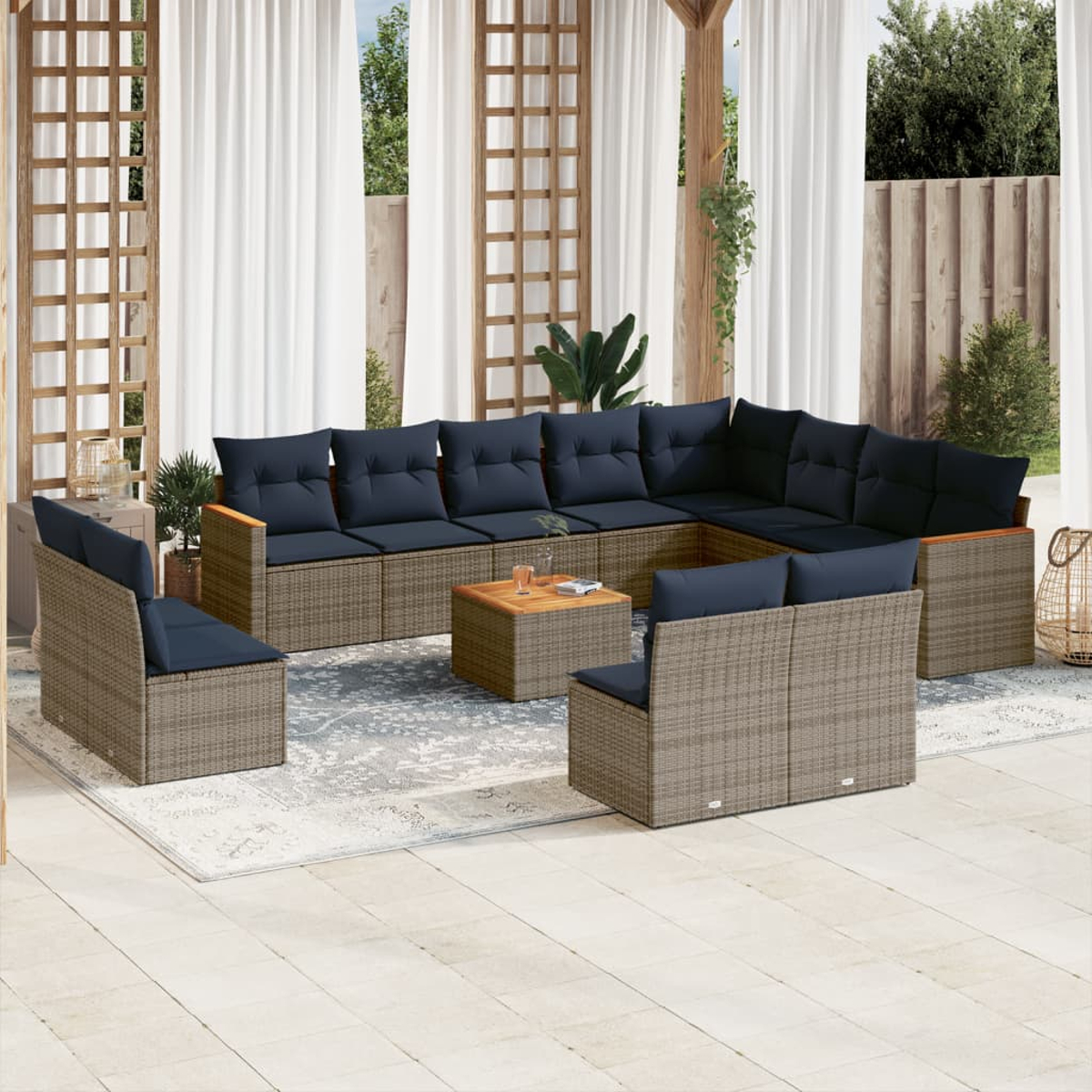 Gartenmöbel-Set mit großem Ecksofa, zwei Sesseln und einem Couchtisch. Marineblaue Kissen auf beigen Korbmöbeln.
