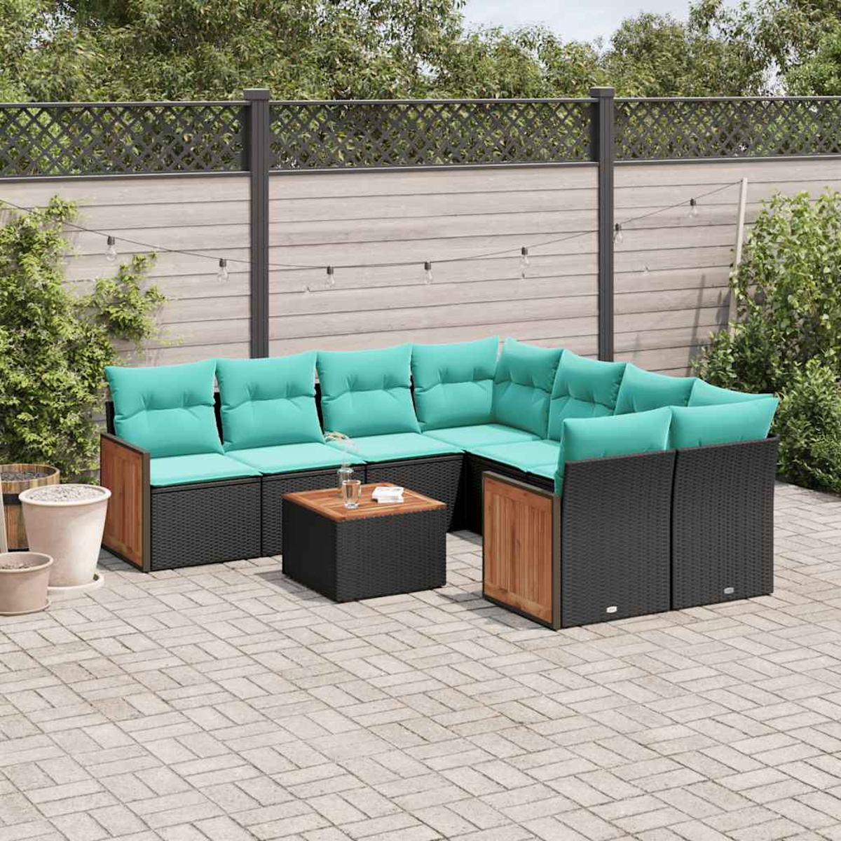 Outdoor-Ecksofa mit türkisfarbenen Kissen und einem Holztisch auf einer gepflasterten Terrasse. Im Hintergrund ein Holzzaun und Grün.